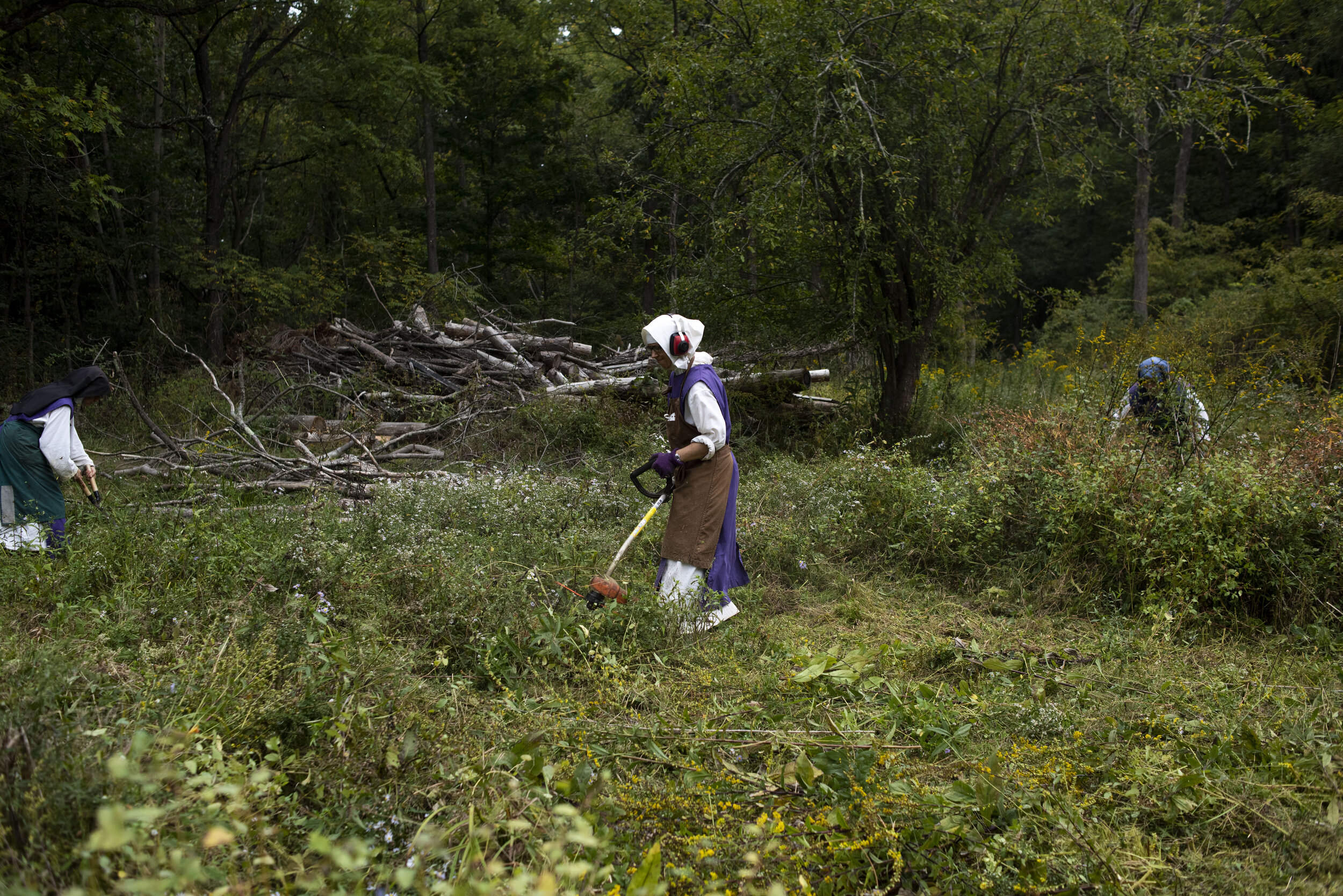  Sister Mary Consolata trims down weeds in a pasture that the Sisters of Mary planned to use for livestock.  