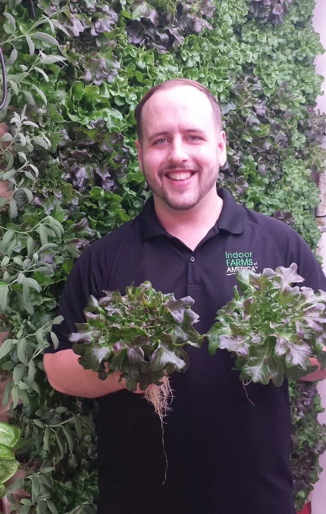 Indoor Farms of America corporate Farm Manager Anthony Randolph grows beautiful greens in the vertical aeroponics from IFOA.
