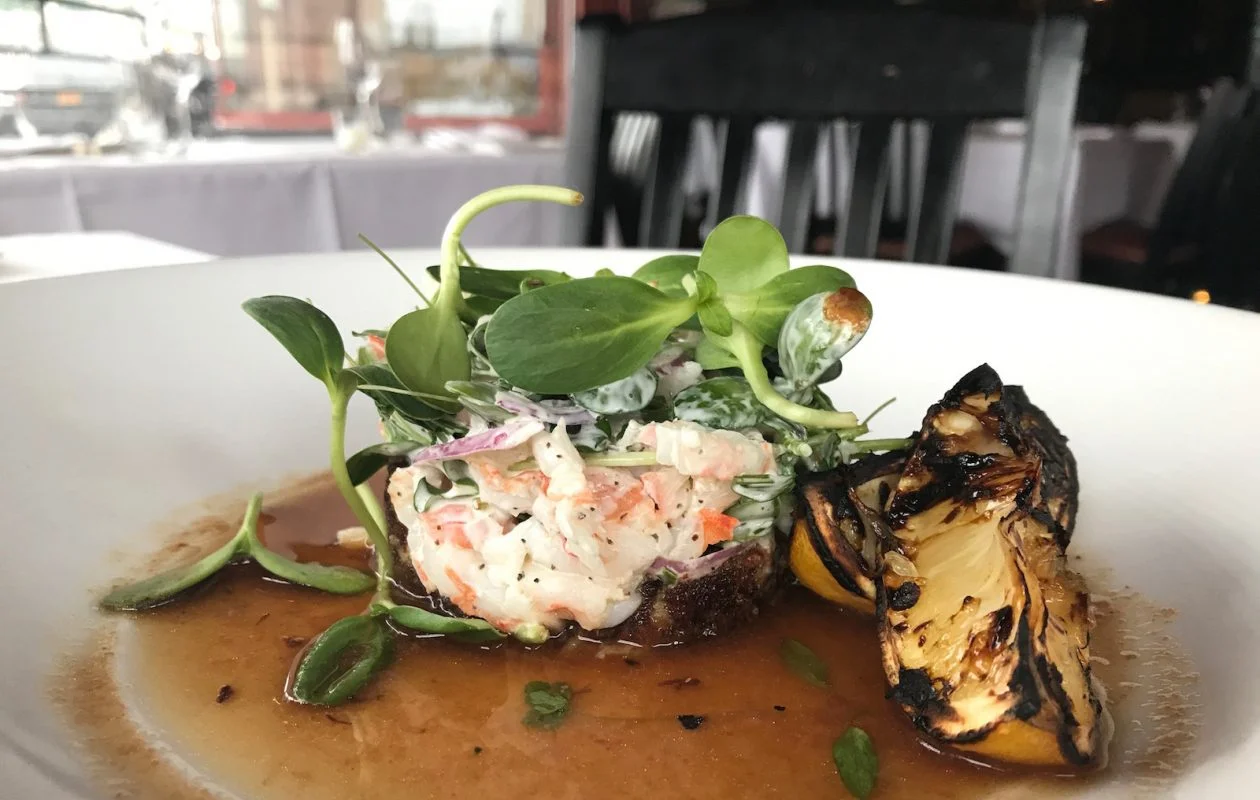 Cold shrimp and crab salad with charred tomato-citrus broth and Vertical Fresh Farms sunflower microgreens was a recent menu feature at Bacchus Wine Bar & Restaurant. (Caitlin Hartney/Special to The News)