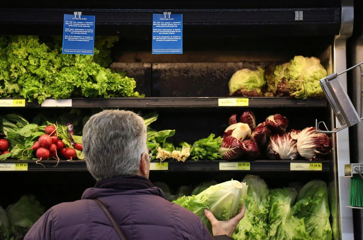 Lisa Dennis selects lettuce from the vegetable shelves at the East End Food Co-op Federal Credit Union in Pittsburgh on Nov. 20. (Jessie Wardarski/Pittsburgh Post-Gazette/AP)
