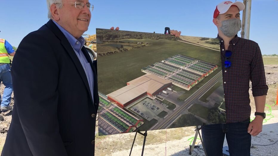Lockhart Mayor Lew White (left) and Iron Ox co-founder and CEO Brandon Alexander stand next to a concept drawing of the new Iron Ox facility being built in Lockhart.&nbsp;(City of Lockhart)