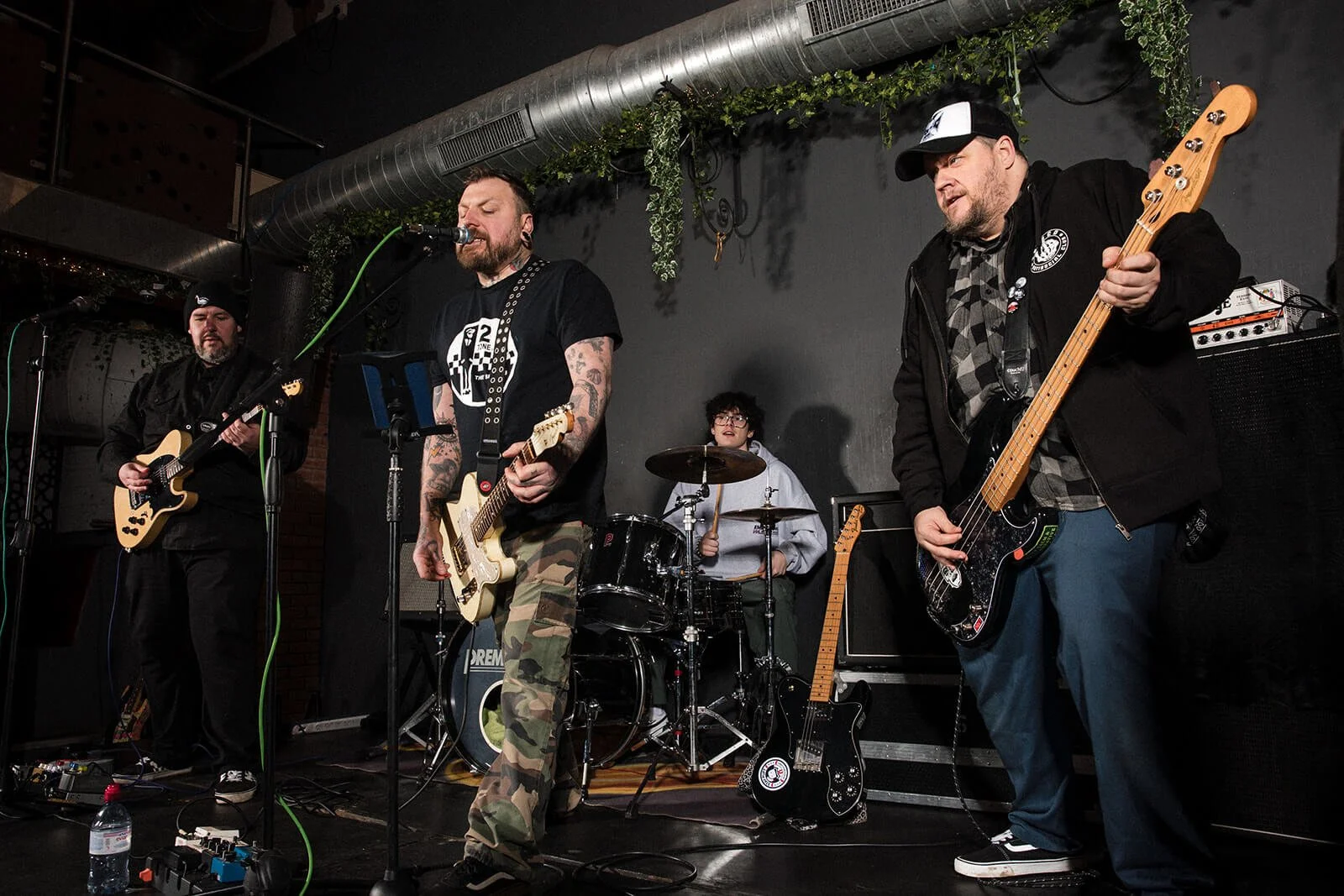 Four band members playing instruments at a gig