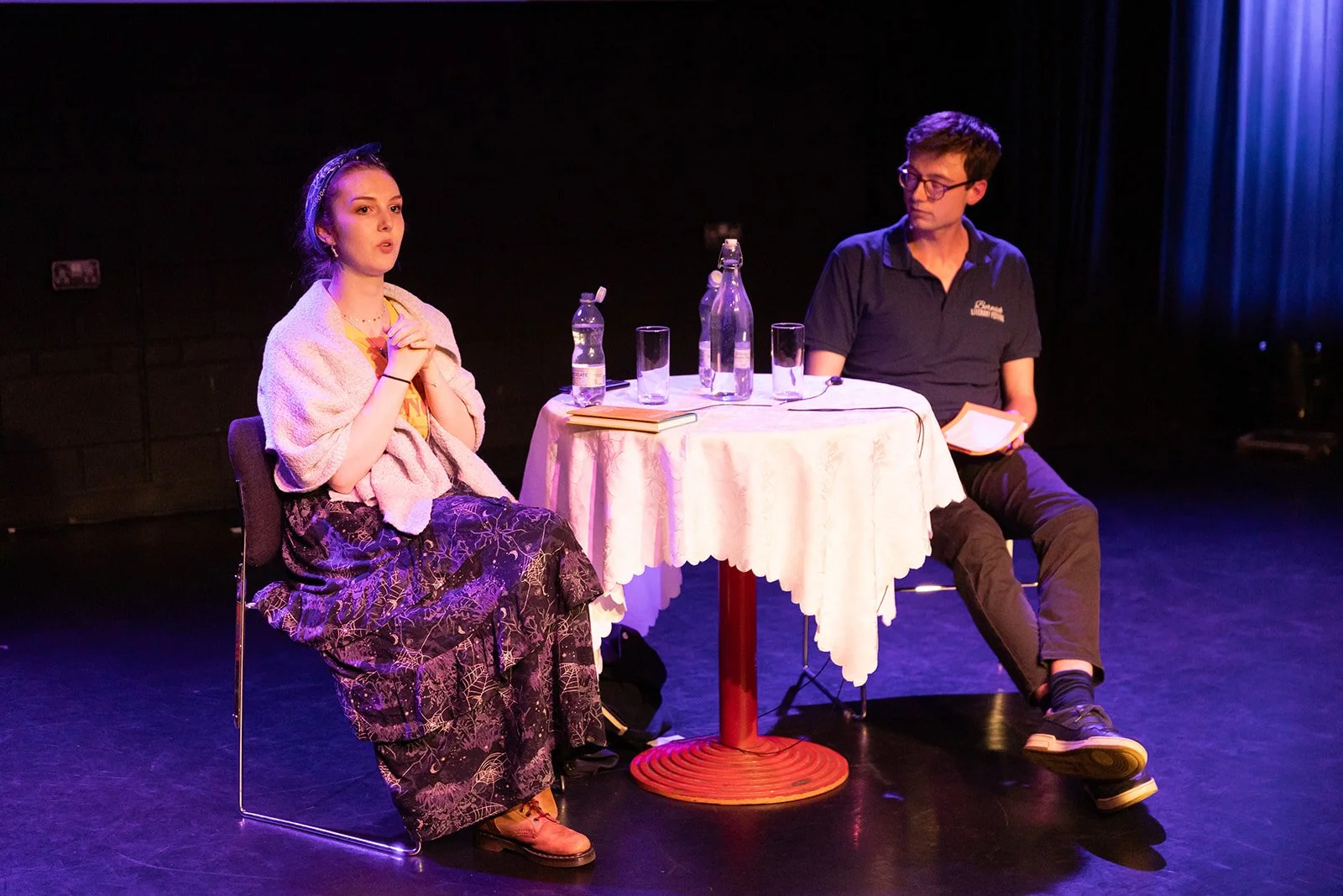 A poet called Len Pennie reading some f work infront of an audience at the maltings