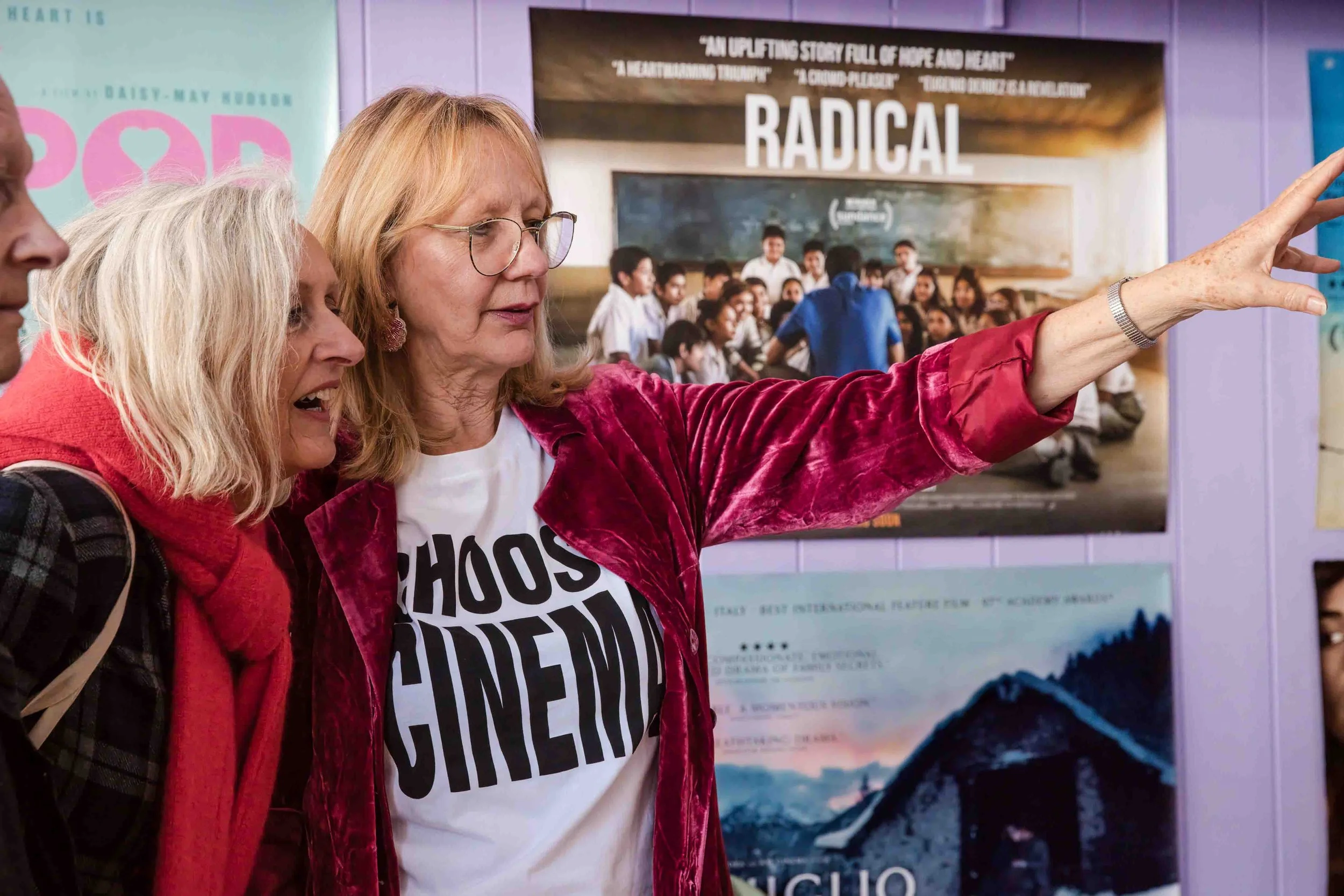 Guests talking inside Jackal at Berwick Film Society’s 21st birthday event, surrounded by colourful film posters.