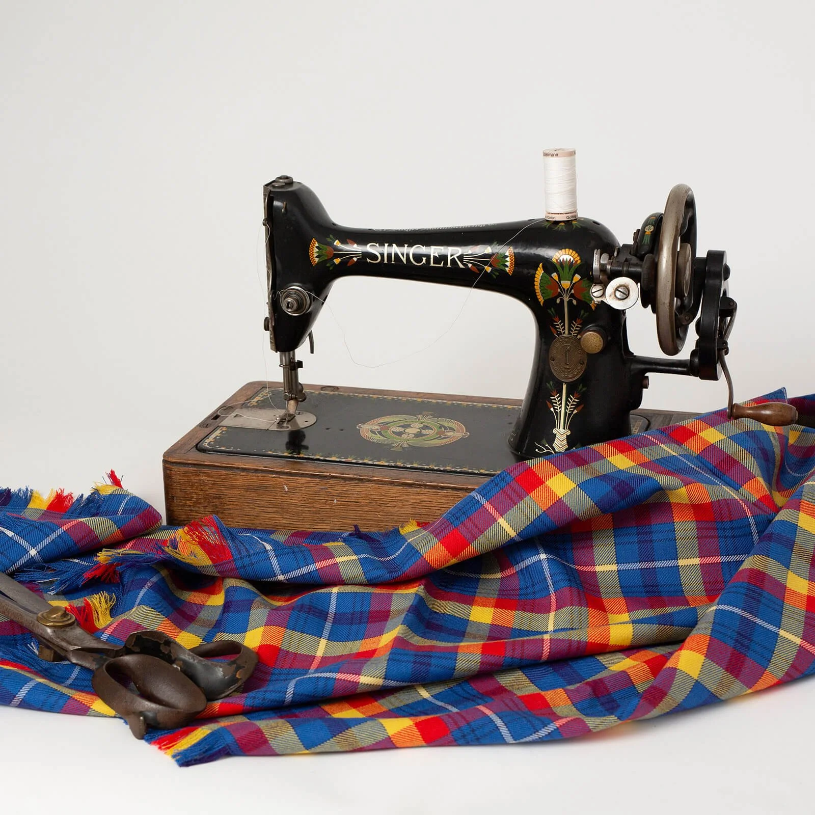 One of International Tartans fabrics showing the craftsmanship with a singer sewing machine and scissors on a branding shoot in our studio in Berwick-Upon-Tweed