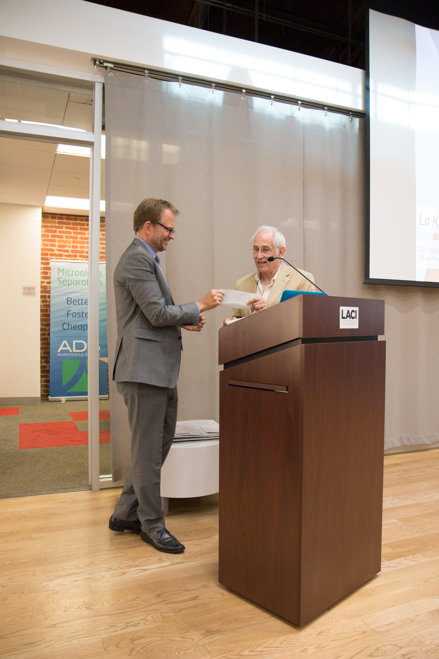 LACI CEO Matt Petersen accepting the $10,000 award from Simeon Bruner, Founder of the Rudy Bruner Award for Urban Excellence
