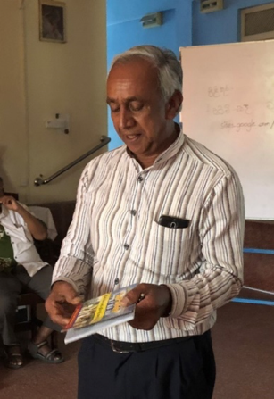 Mr. Dharmasena shows off the program book from a concert that netted Rs. 30 million.