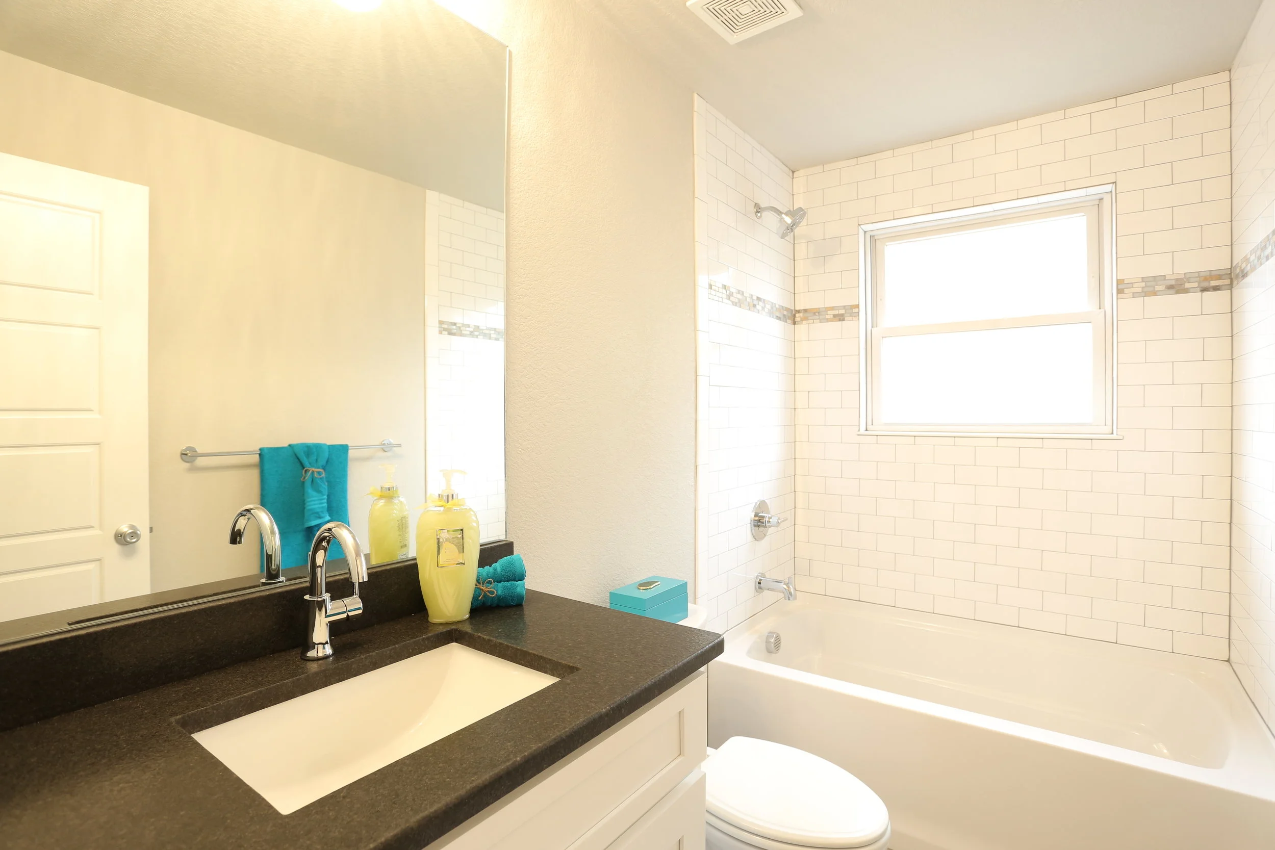 updated full guest bath with leathered granite counters, new fixtures, and new tile