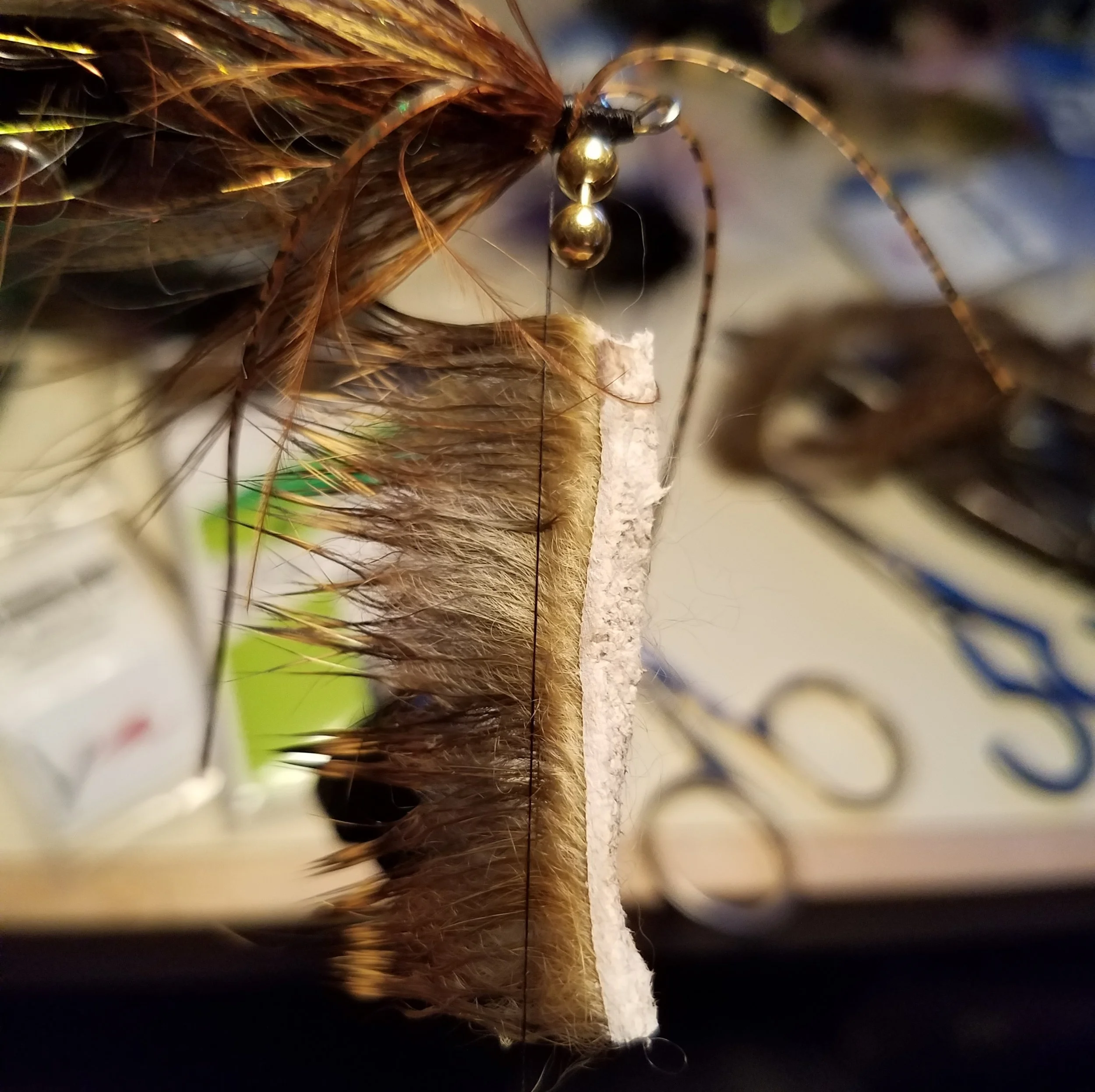 A RABBIT FUR COLLAR AND WOVEN THROUGH THE BEAD CHAIN EYES. USING 4 BEAD CHAIN EYES HELPS SINK THE FLY A BIT AND KEEP IT ORIENTED CORRECTLY (THANK YOU GREG SENYO FOR THE TIP!)