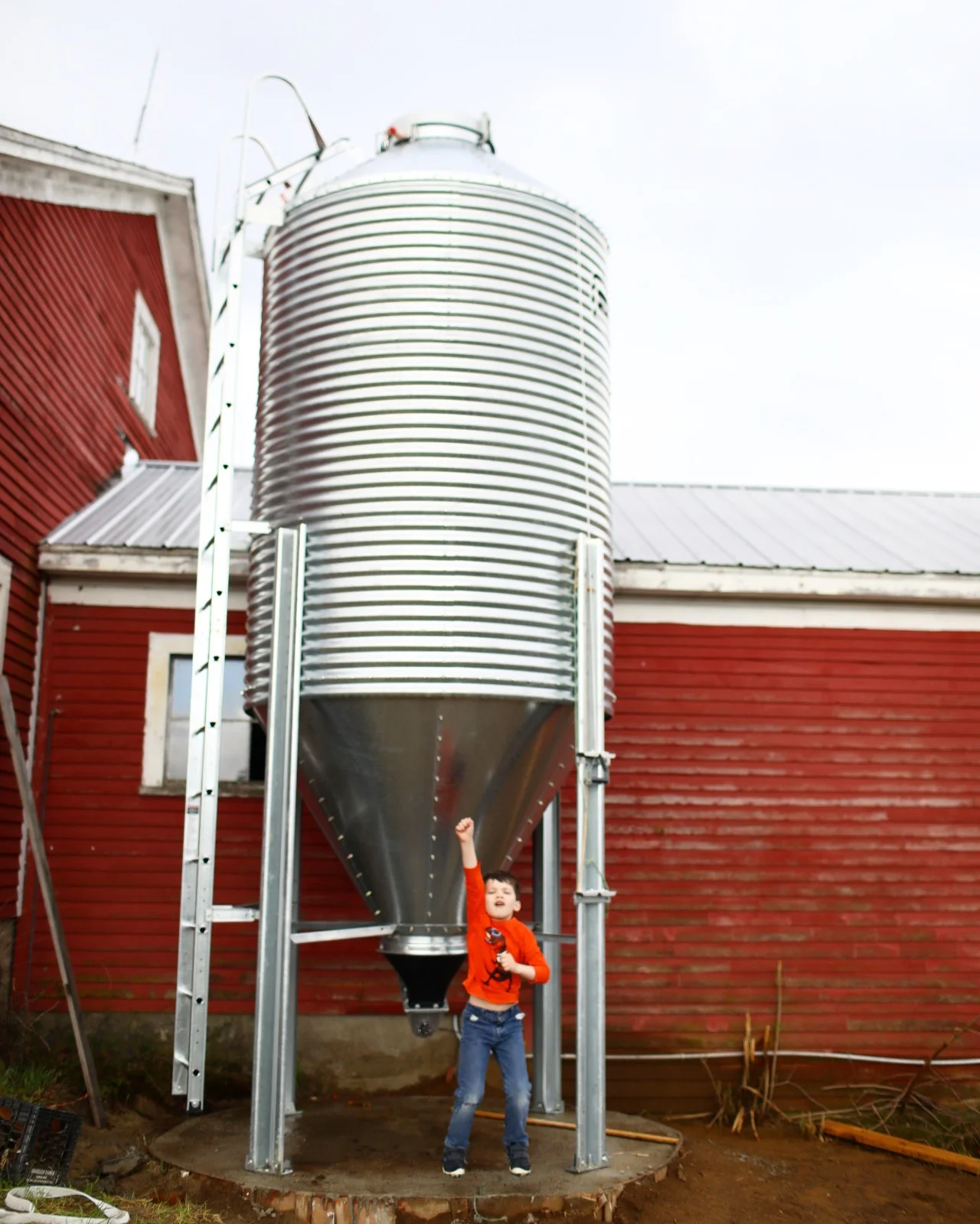 Hank {age 6} jumping for joy with the new Brock silo! {While it was being built, all the kids pretended it was a spaceship and spent endless hours inside...and also put to work tightening some bolts!}
