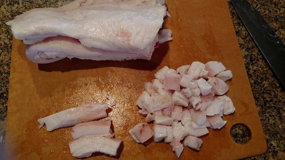 Cut uniform cubes of pig fat and place them into a large cast iron skillet. The size of the cubes of fat doesn’t matter as much as trying to make them relatively close to the same size. I did one-inch cubes. This will help all the fat to render evenly; and you won’t have to deal with fishing smaller bits of fat out that would burn more quickly than larger pieces. Also make sure that all the bits of muscle have been cut off the fat. Bits of burned meat will compromise the flavor of your finished lard.