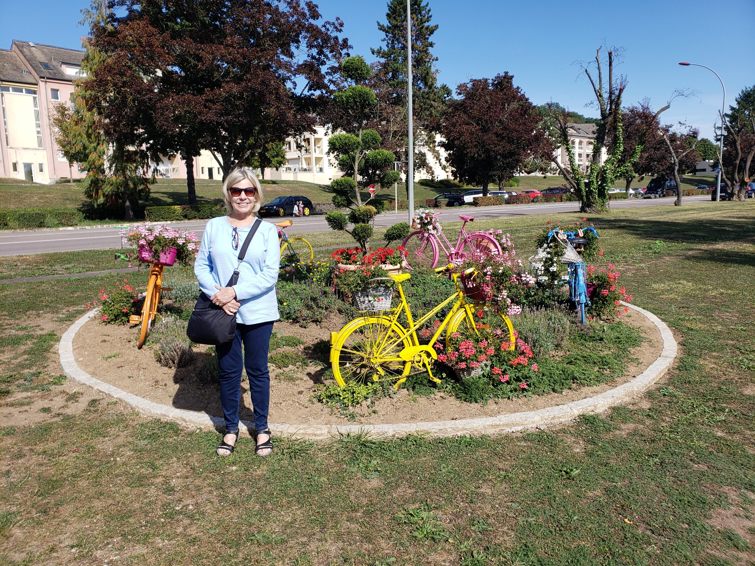  Jeri in front of a beautiful flower garden by the Moselle River in Remich, Luxembourg 