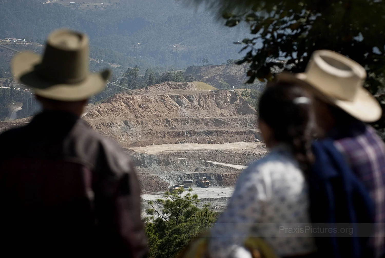 OPEN PIT - The people of San Miguel Ixtahuacan, in Guatemala, look on at the steadily growing Marlin Mine. Open-pit mines are typically enlarged until either the mineral resource is exhausted, or until the operations are no longer profitable. Gold mining produces 79 tones of largely toxic waste for every ounce of gold. Many of the indigenous peoples living next to these mines struggle to comprehend the point of it all. “Who came up with the idea that gold should be worth so much anyway?” asks Alejandro, “it’s only a yellow stone that shines! Life should be more valuable than gold.”