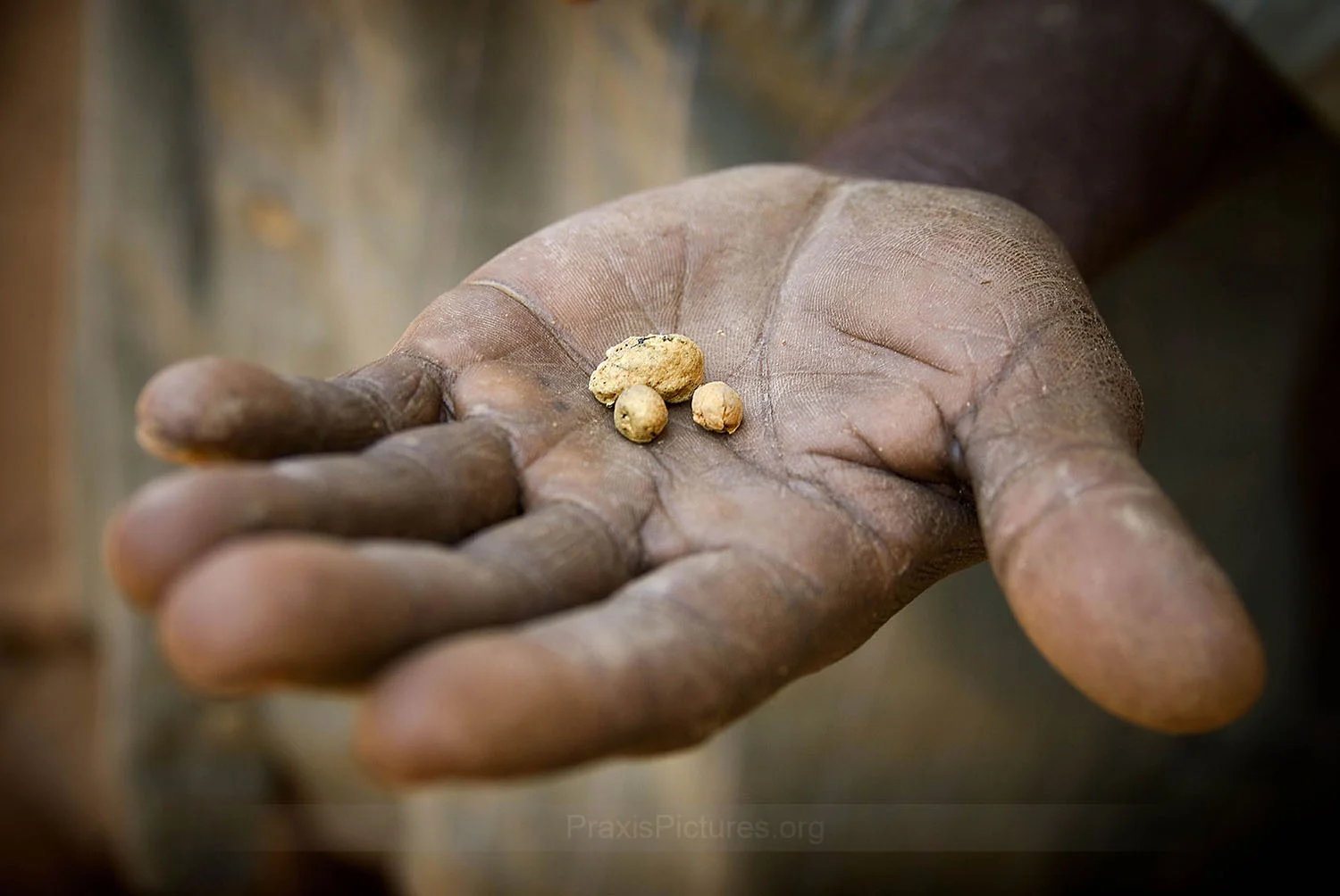 THE PRICE OF GOLD - An artisanal miner in Tanzania holds out some gold nuggets. The price of gold has been skyrocketing, reaching record high prices in recent years. Multinational mining companies search the ends of the earth for these, and other, valued natural resources. Meanwhile, the people who just happen to live there are the ones who usually end up paying the price. For minerals that mean little to them, for profits they never see, the price they pay includes the very things that they treasure most – including the loss of traditional lands, livelihoods, health, culture, and loved ones.