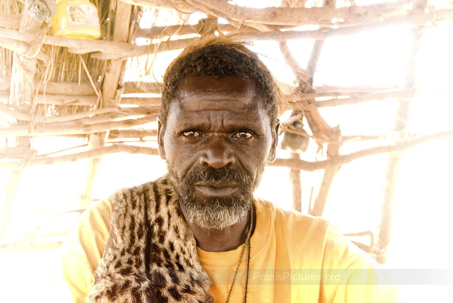 DEOGRATIOS - Deogratios is the traditional witchdoctor, or medicine man, of the indigenous community. He was among the thousands of people who were evicted to make way for the Bulynhulu Gold Mine in Tanzania. He remembers being forced from his home by heavily armed paramilitary forces only one day after the Minister of Minerals and Energy had issued an order giving the Bulyanhulu residents one month to vacate the area. Deogratios and his family had nowhere to go, so for two months after being forced from their home they were living in the bush. During this time his wife became ill. But with their home destroyed, and without access to his medicines, the healer could do nothing as he sat and watched his wife die.