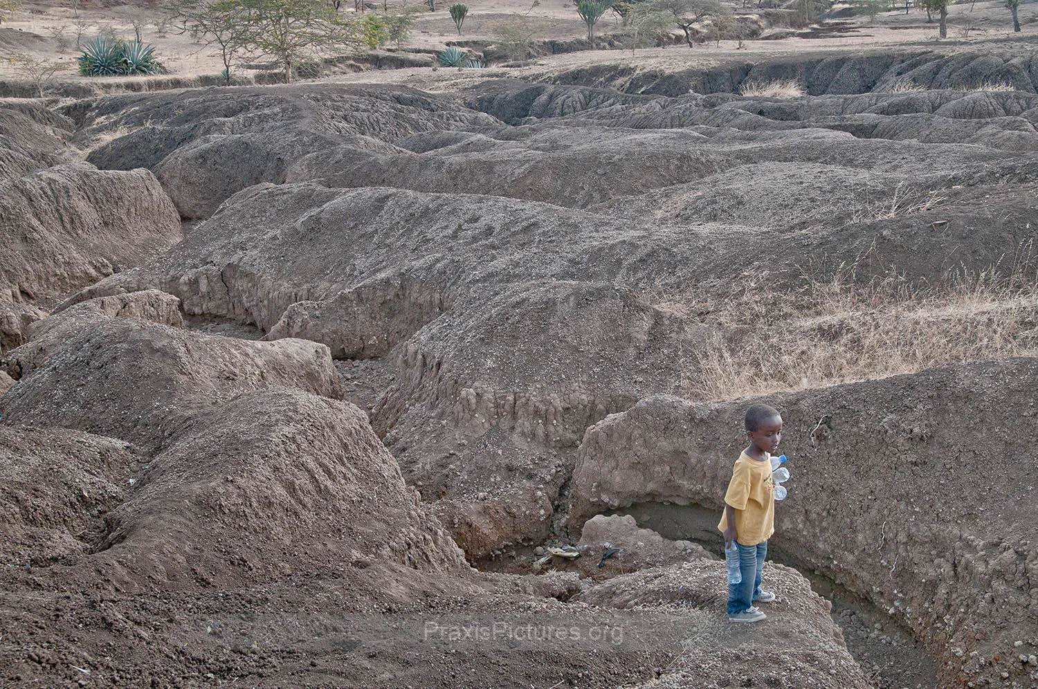 SOIL EROSION - The parched earth has altered the landscape surrounding Ngorbob. Once green fields have eroded leaving the area dangerous for the local children like Baraka.