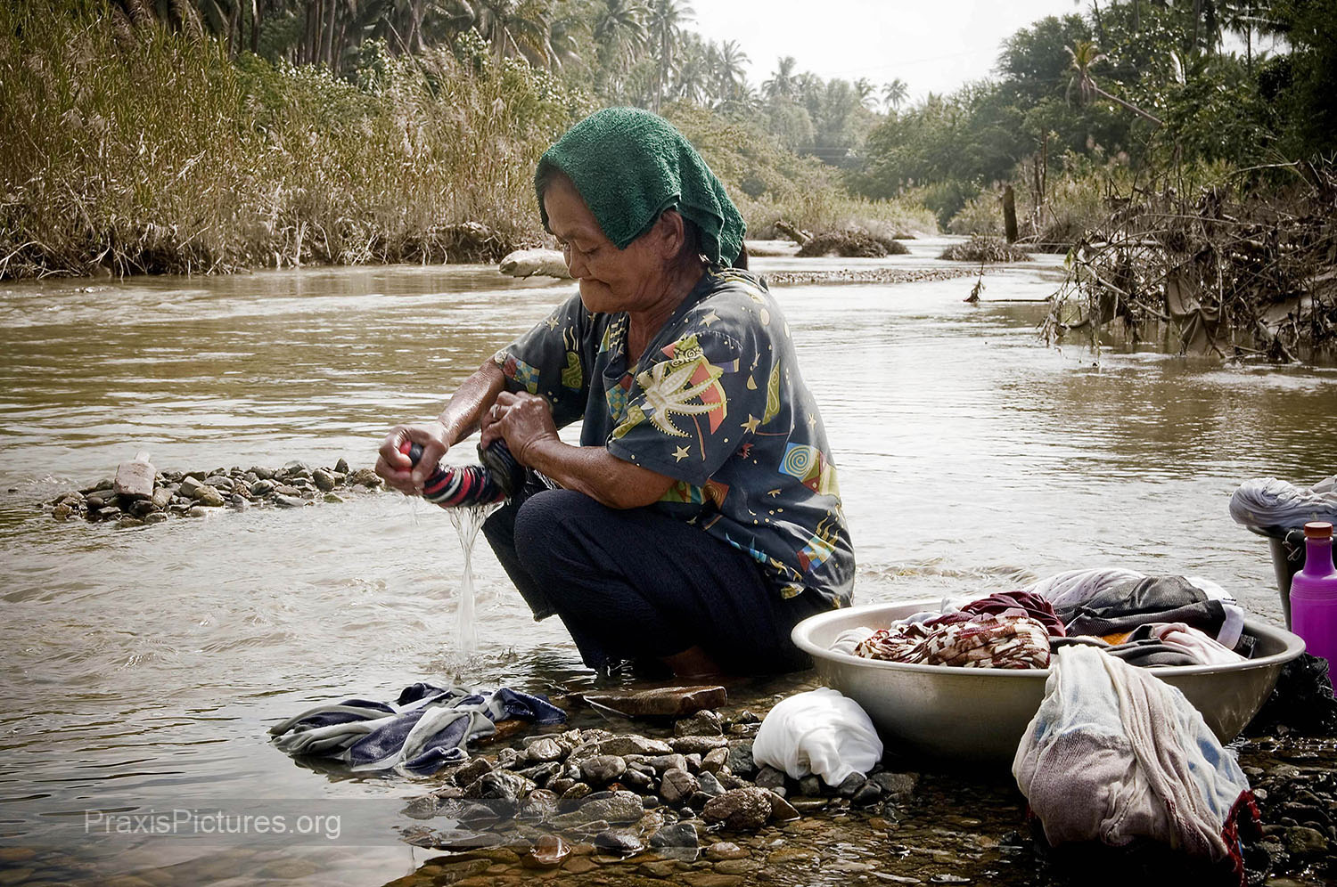 REMY - Remy washes her laundry in the poisoned Mogpog River in Marinduque. In 1993 one of the tailings dams of Placer Dome’s copper mine burst sending tons of mine waste raging down the river in a flash flood sweeping away homes, people and livestock. Three years later a second collapse sent waste in the opposite direction destroying the Boac river. Fifteen years on both rivers remain biologically dead and contain dangerous levels of toxic chemicals. Dead trees and other debris can still be seen all along the rivers. But people here have no other water sources to rely on. The company continues to deny any responsibility for what was the worst industrial disaster in Philippine history. After being ordered by the government to clean up their mess, the company responded by packing their bags and sneaking out of the country.