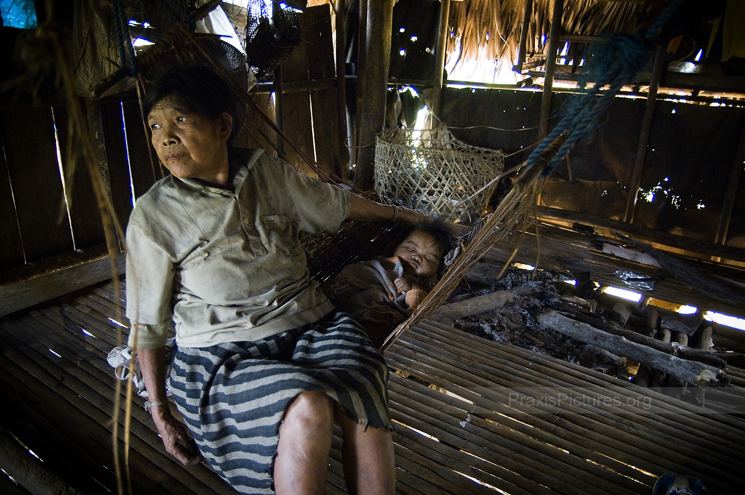 LUNINGNING - Luningning , of the Alangan tribe, with her granddaughter in the village of Kisluyan. The Alangan are one of 8 indigenous tribes in Mindoro, known collectively as the Mangyans. The Mangyans, who once occupied the whole island, are peaceful people who shy away from confrontation. As more and more settlers began moving to the island, the Mangyans were gradually pushed higher and higher into the mountains. Now, with the proposed opening of the mine threatening to push them off their land, they are left with nowhere to go.