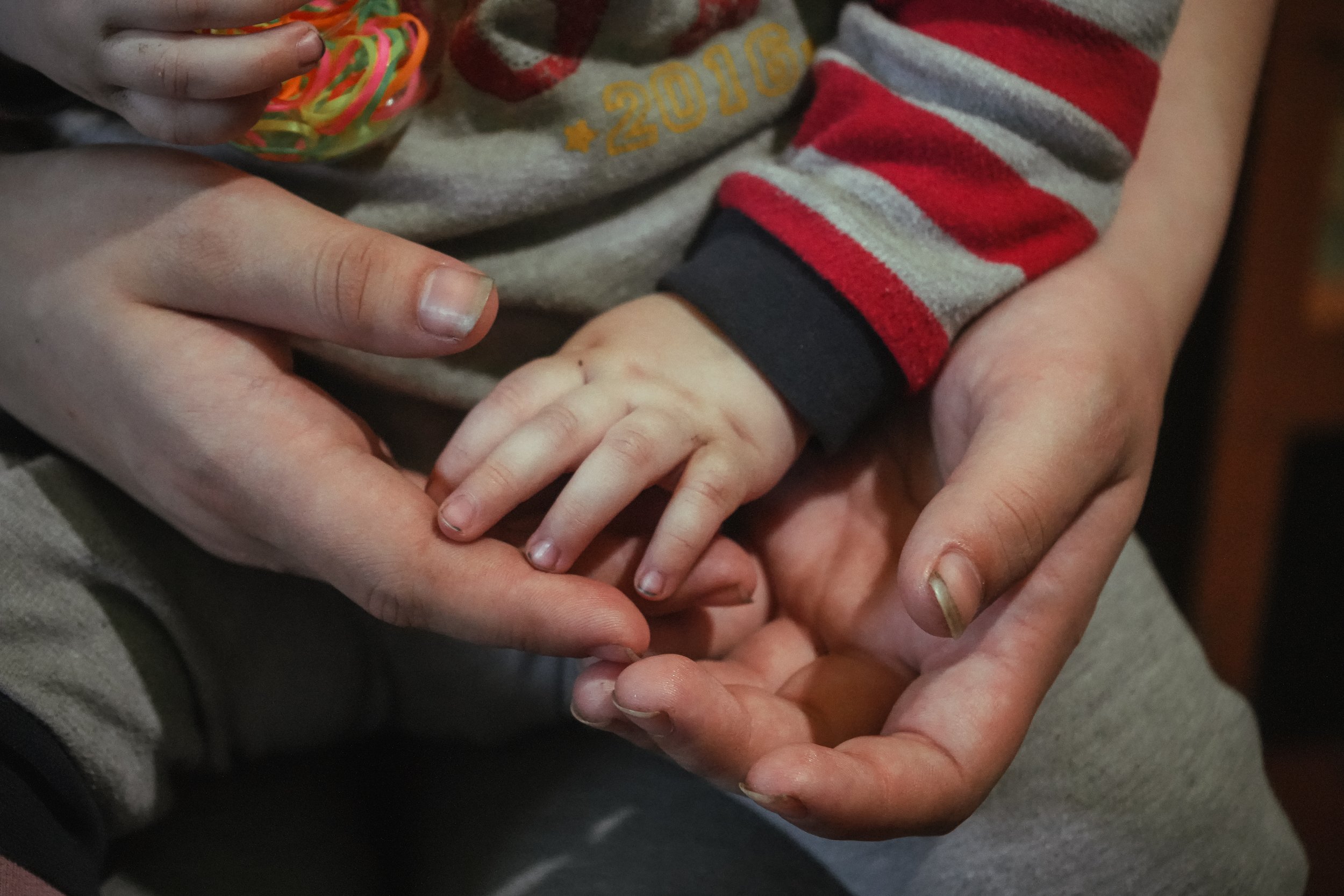 A Ukrainian mother's hands holding the hands of her baby. 