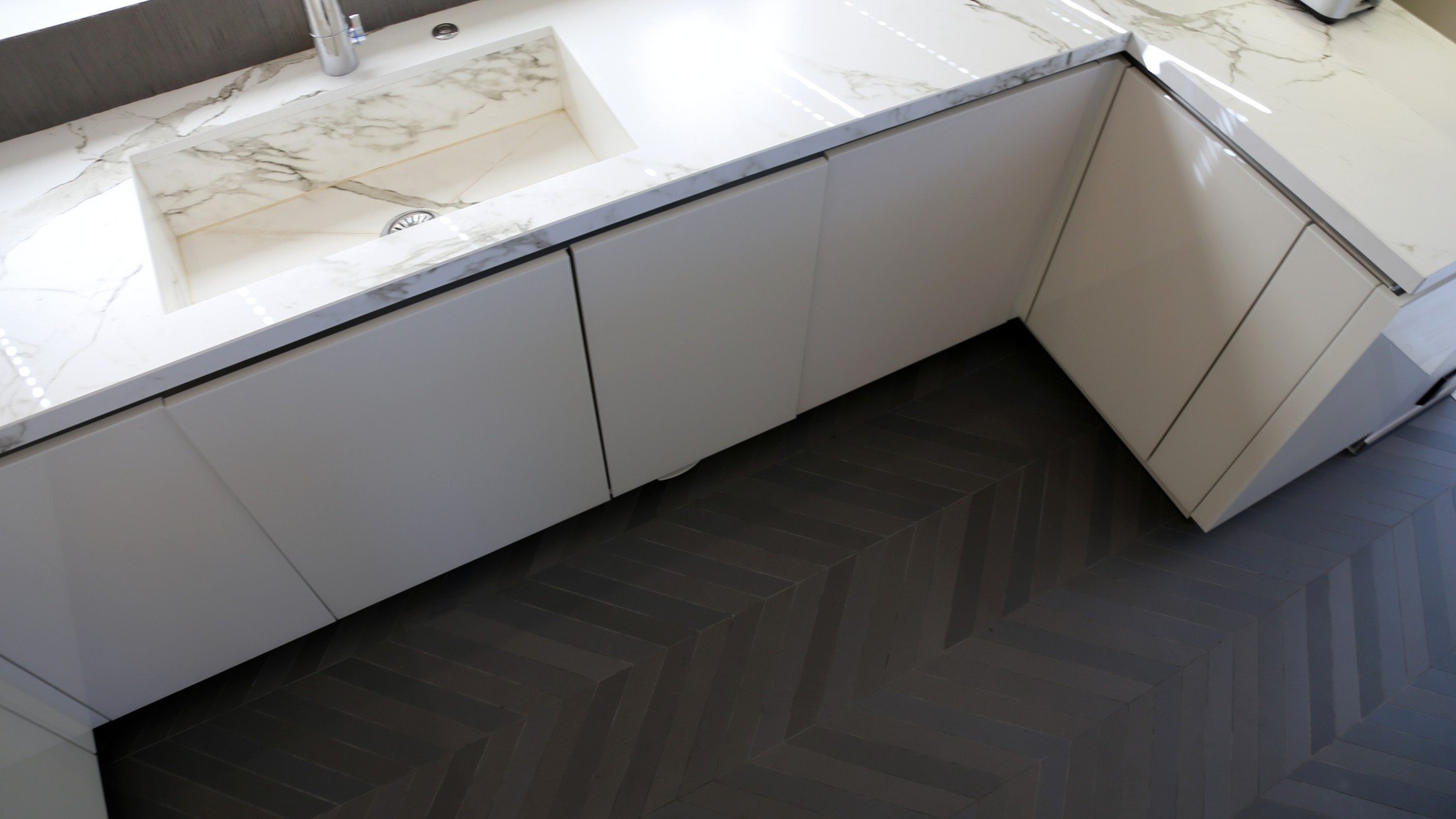 Chevron floor tiles offer a dynamic visual element with their distinctive pattern, especially when laid out meticulously one by one. When paired with modern and sleek kitchen cabinetry, the contrast can be striking, creating a contemporary and stylis
