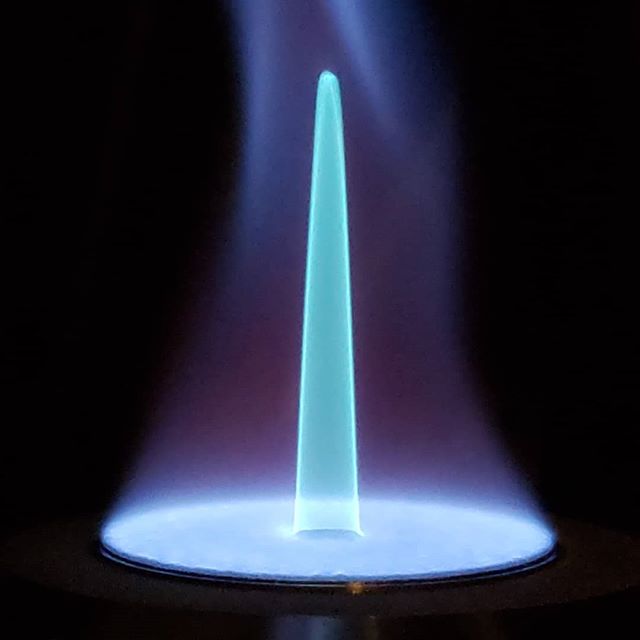 Rich piloted methane flames used for PLIF calibration. The teal color from from chemiluminescence of excited C2* species