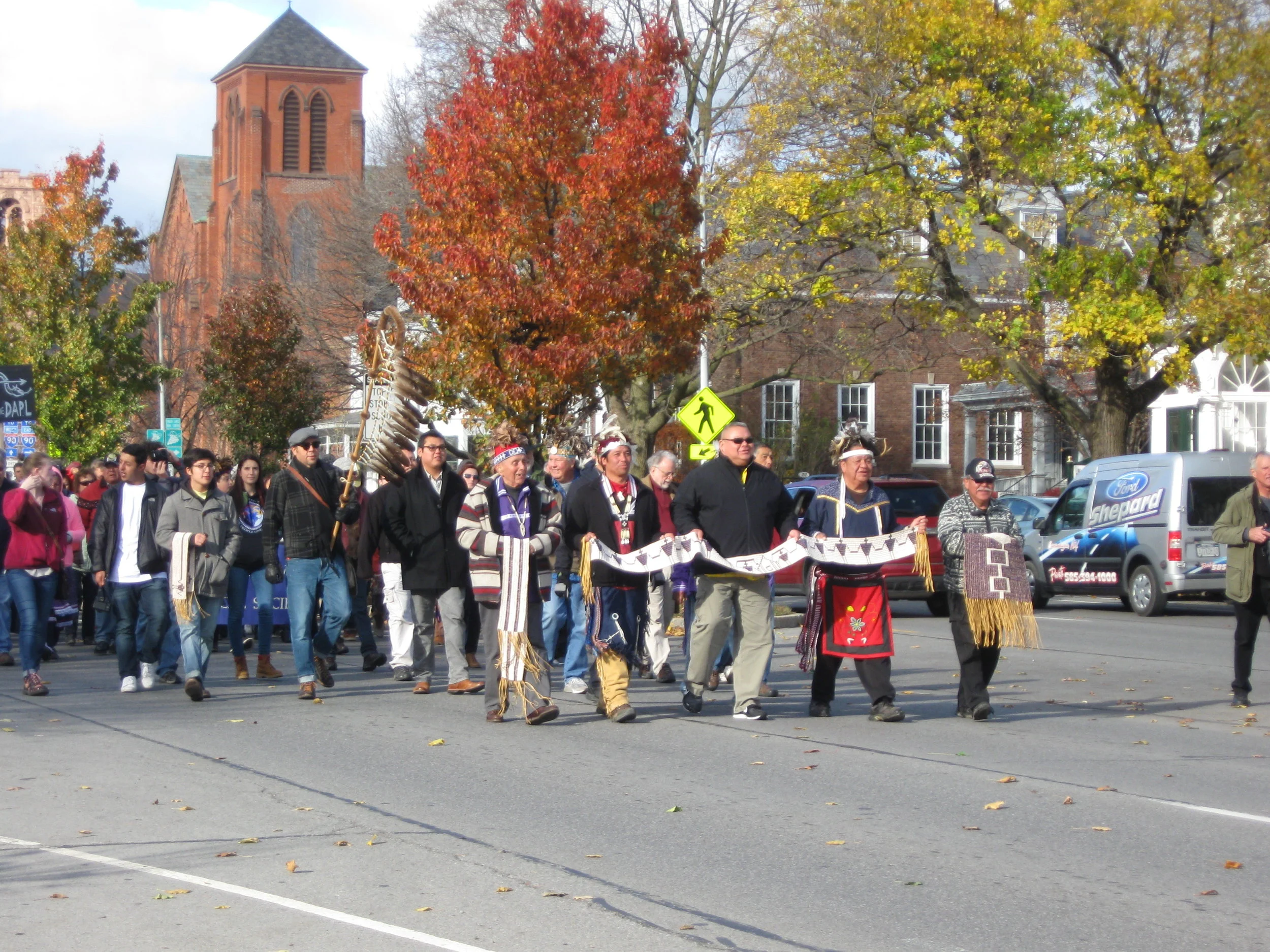 People of the Six Nations and allies walk up Main Street in Canandaigua toward the Ontario County Courthouse.