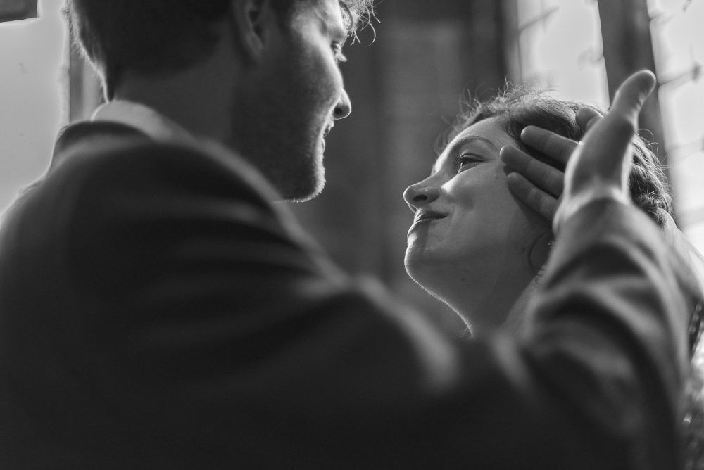 Groom plays with brides hair in a loving moment, in the church of St Michael's Croston Lancashire