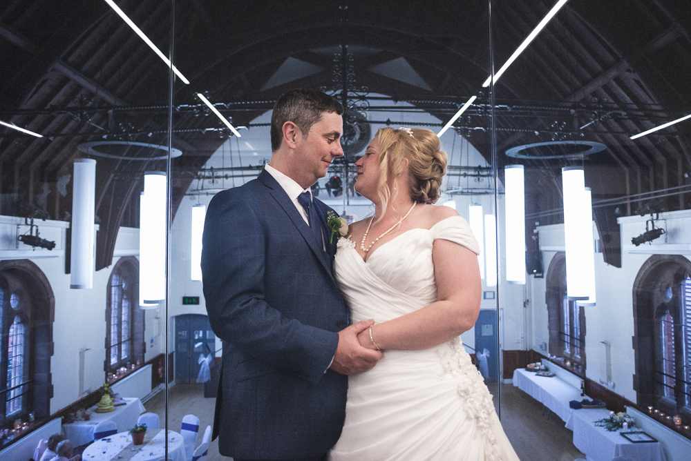 Bride and groom look lovingly at each other, at thier wedding in Sandbach Hall