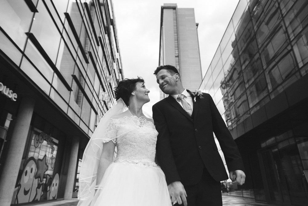 Bride and groom look at each other in Media City, Salford Wedding photographer