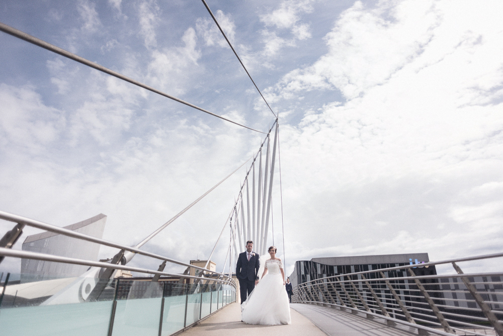 Bride and Groom pose on bridge in Salford's Media City. Wedding photography