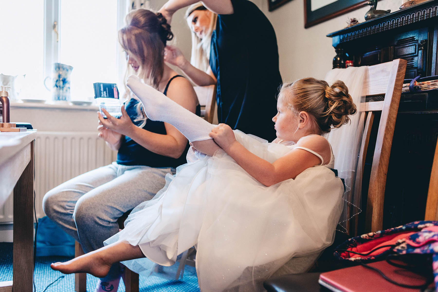Young bridesmaid pulling her socks on