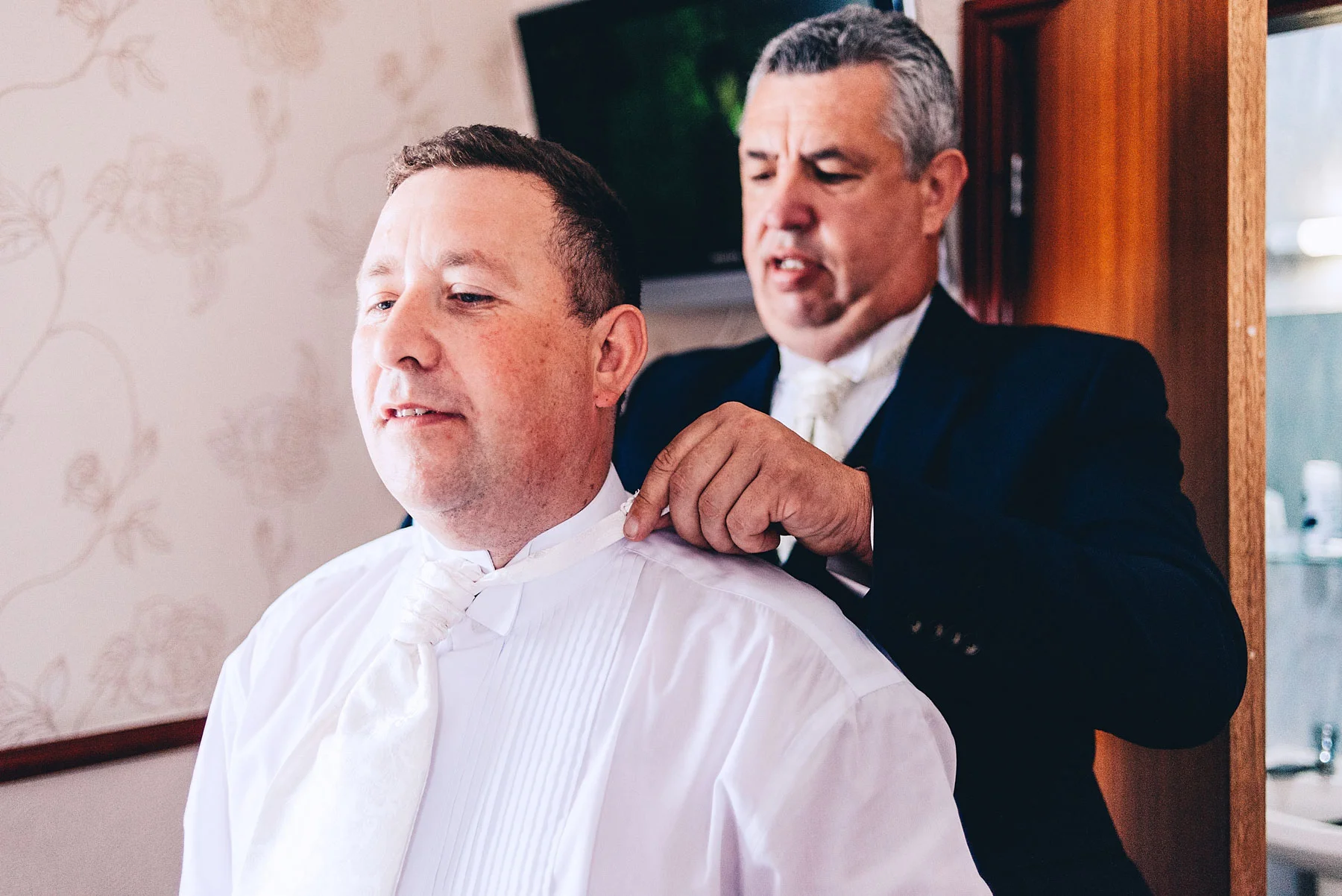 Best man tying grooms tie