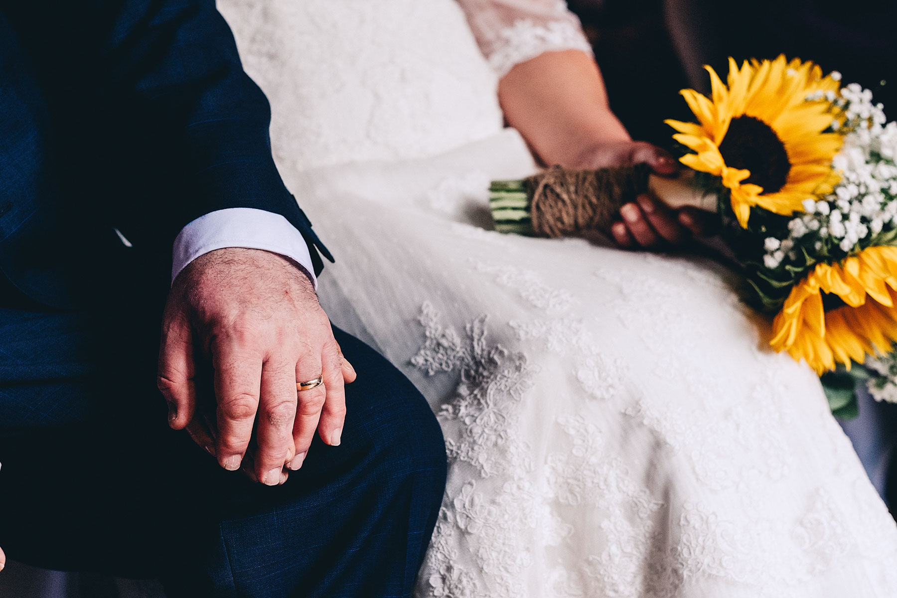 Groom holds bride's hand