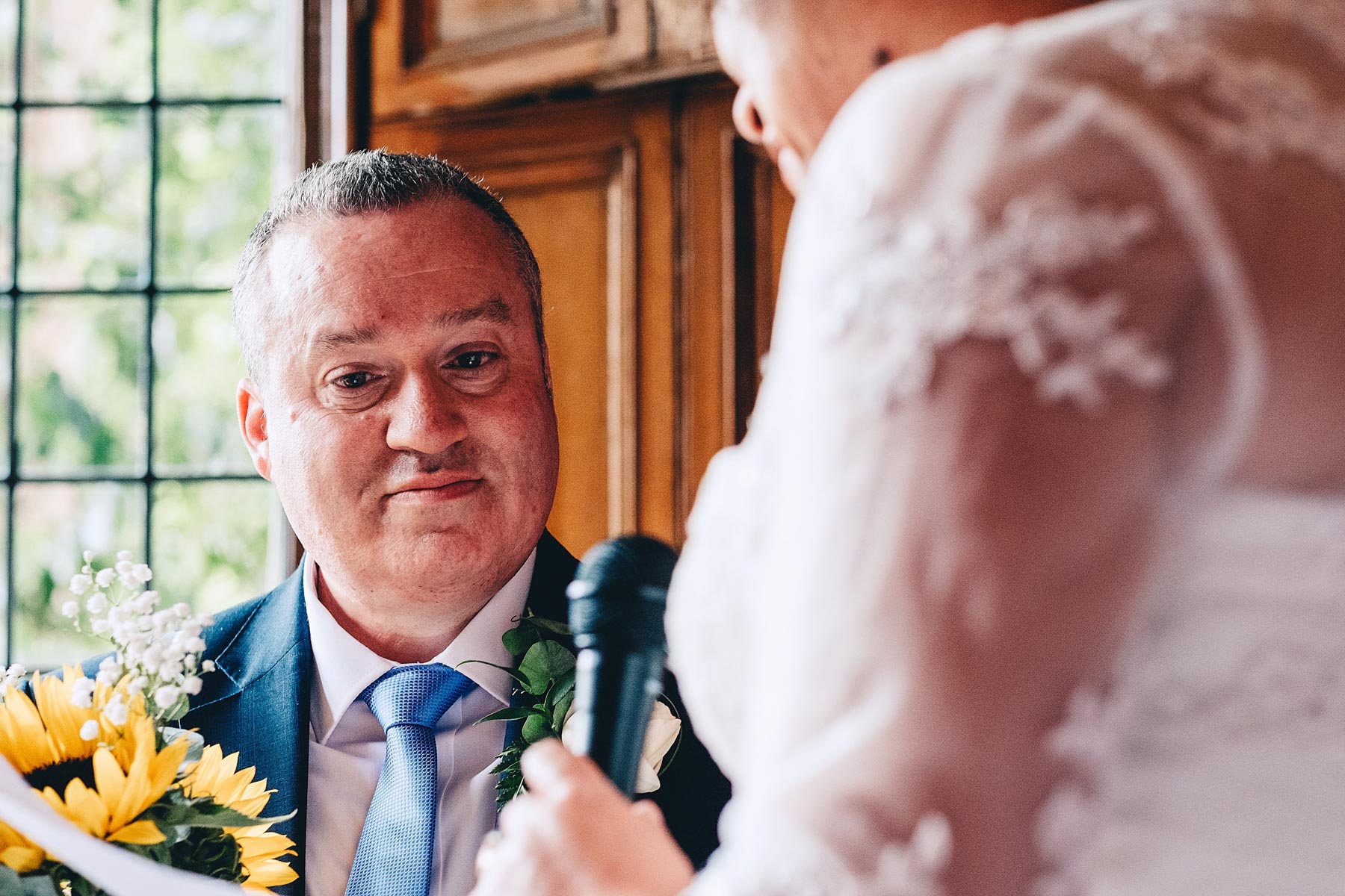 Groom looks lovingly at bride during wedding service