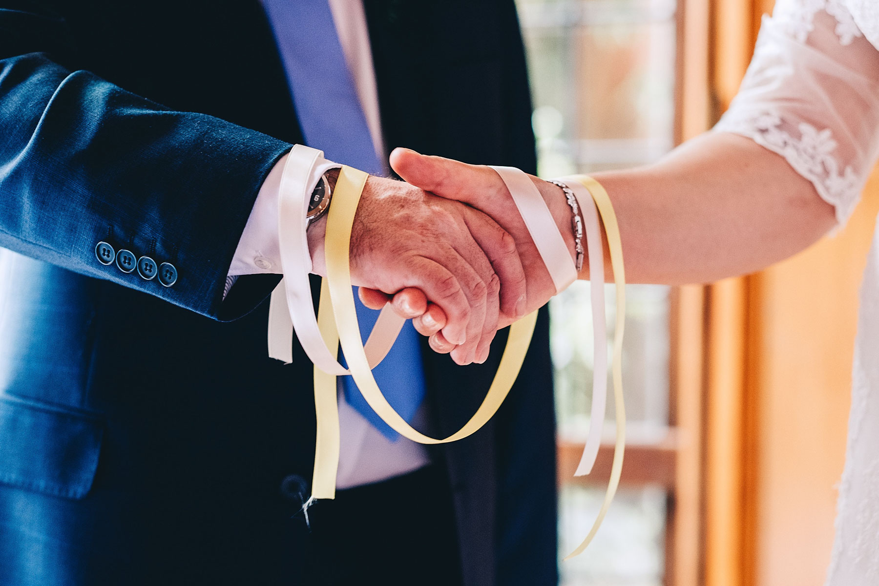 Handfasting ceremony close up of ribbons and hands