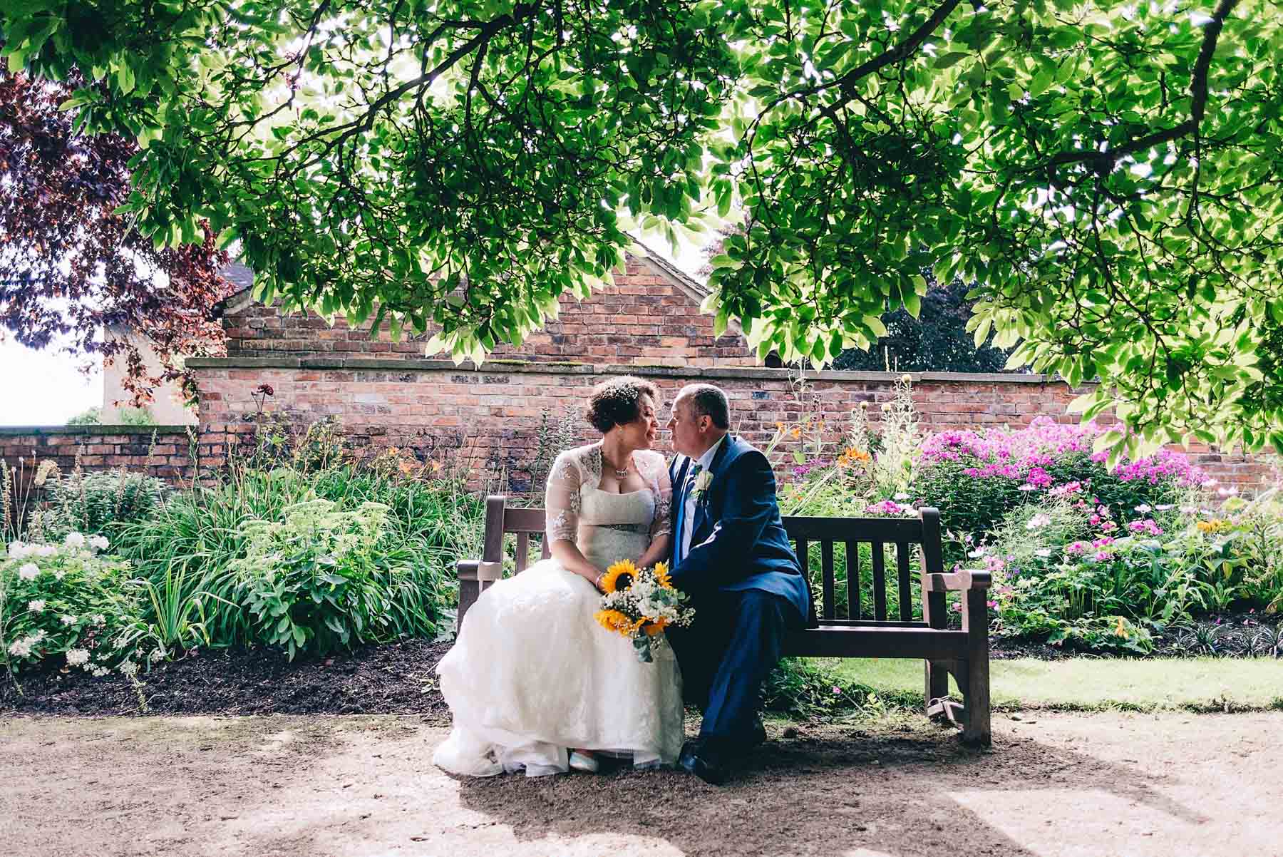 Bride and groom backlit in didsbury parsonage gardens