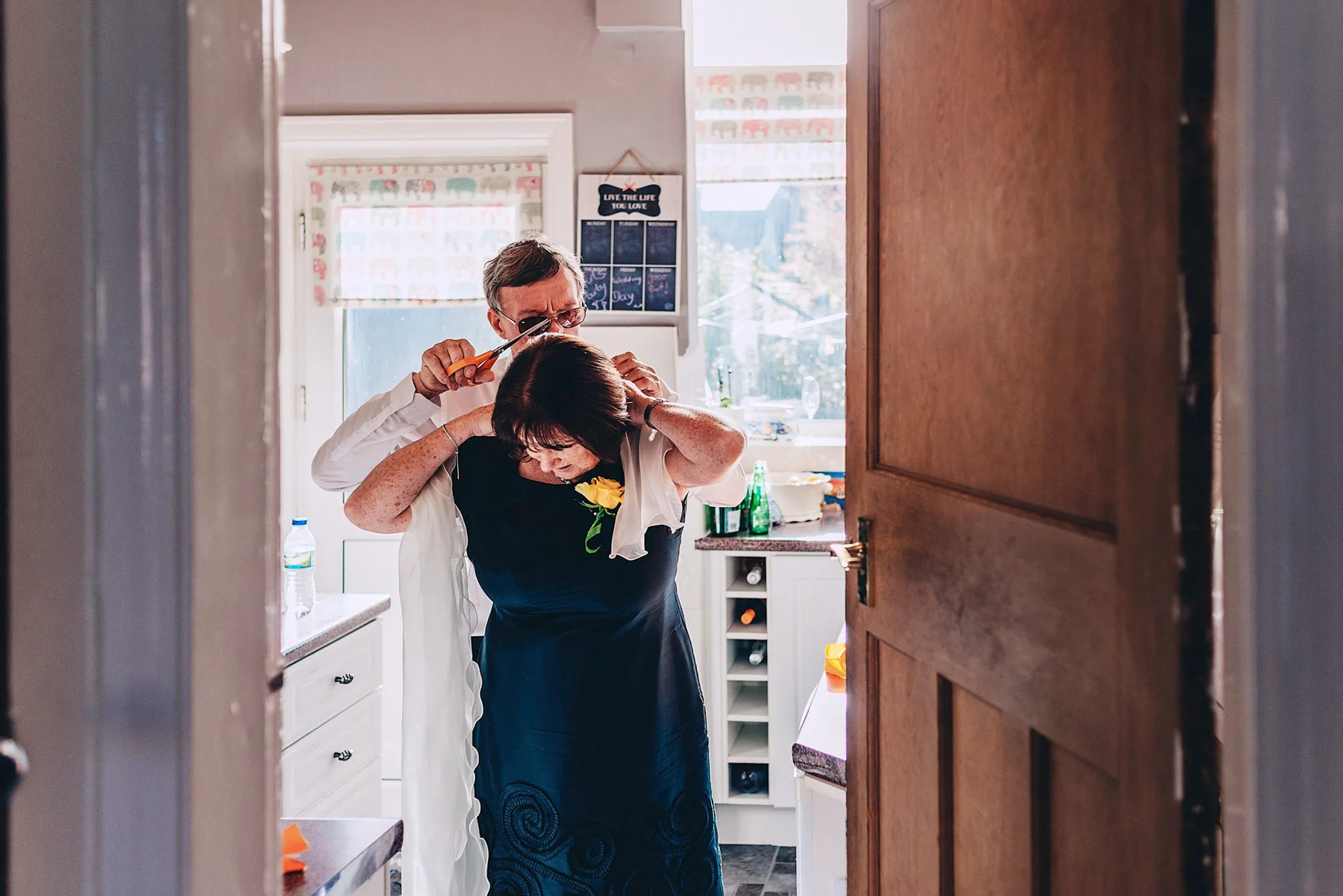 Husband helps wife cut tag of new dress