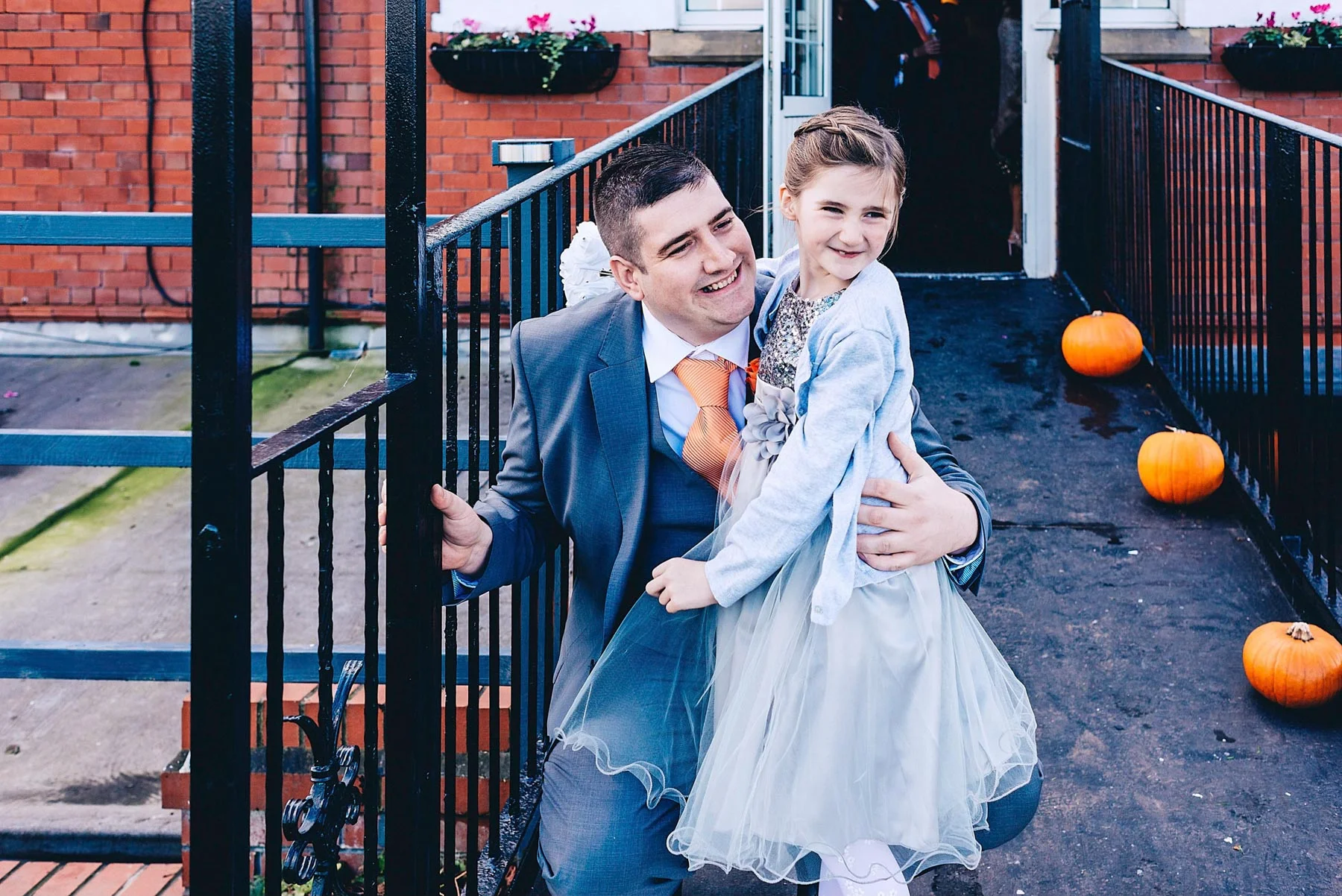 Groom and daughter look towards bride