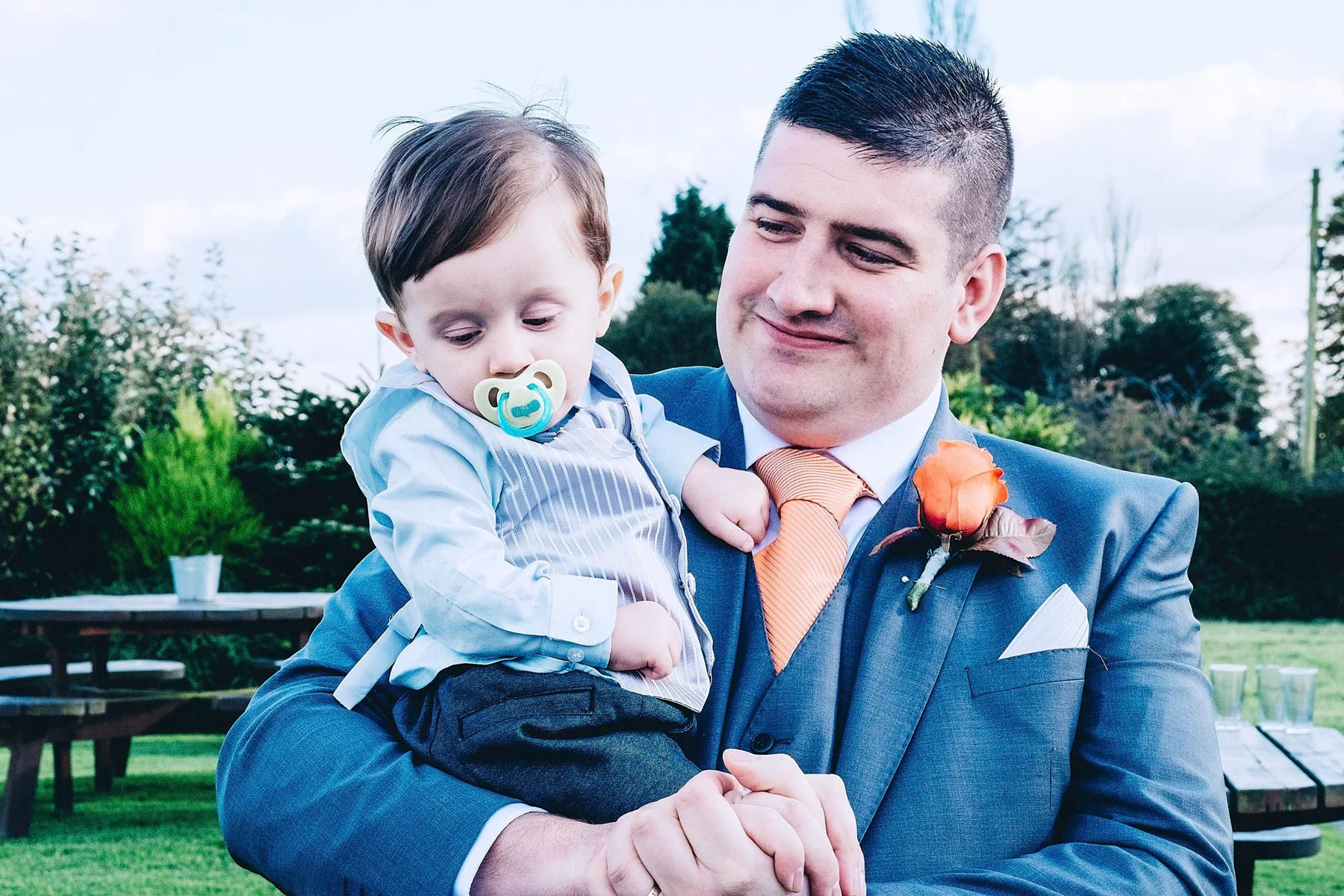Groom holds son proudly