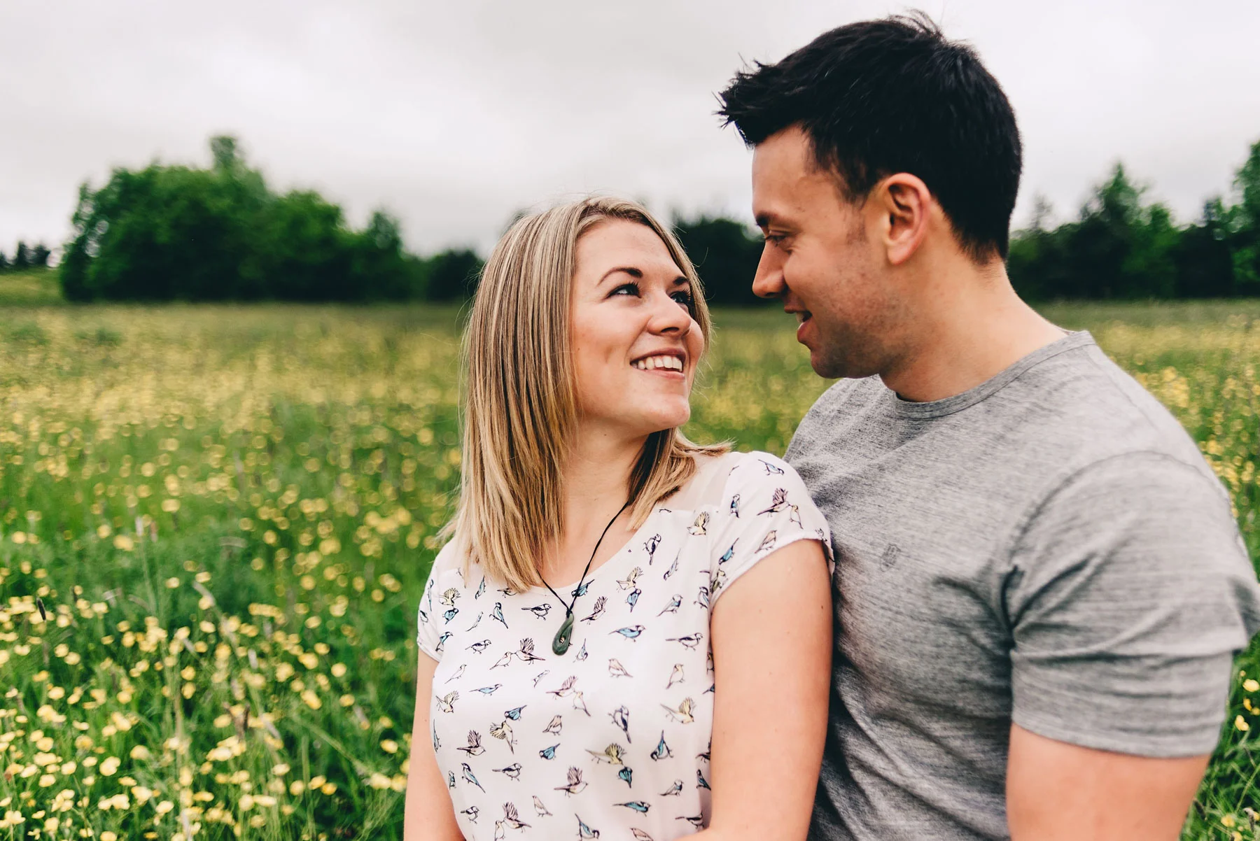 Engaged couple look loving at each other in Holmebrook Valley Park in Spring