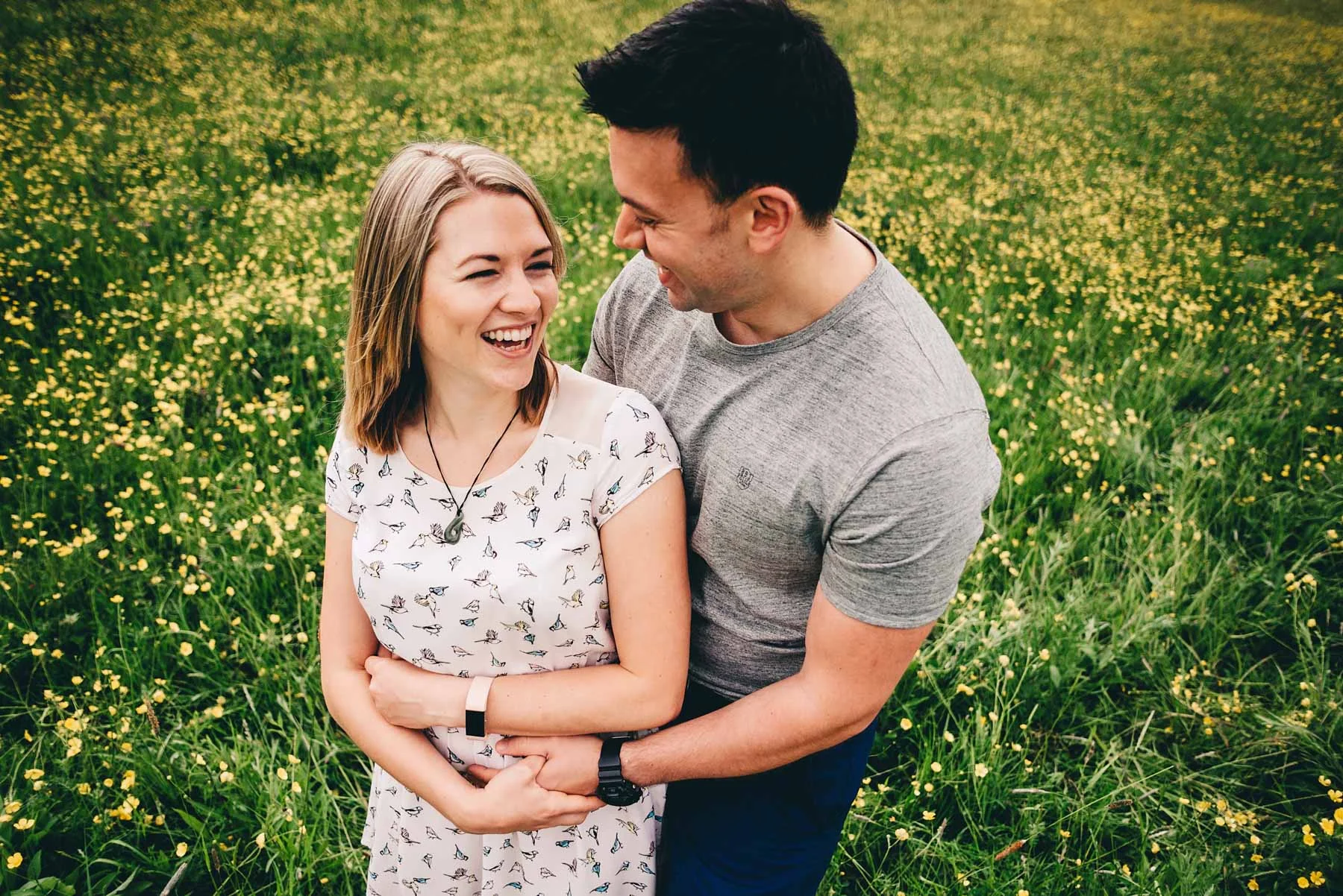 Engaged couple look loving at each other in Holmebrook Valley Park in Spring