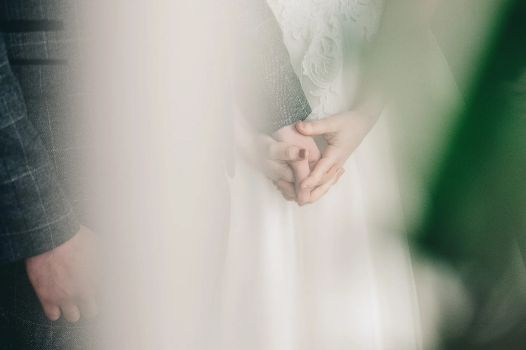 Bride and groom hold hands during service
