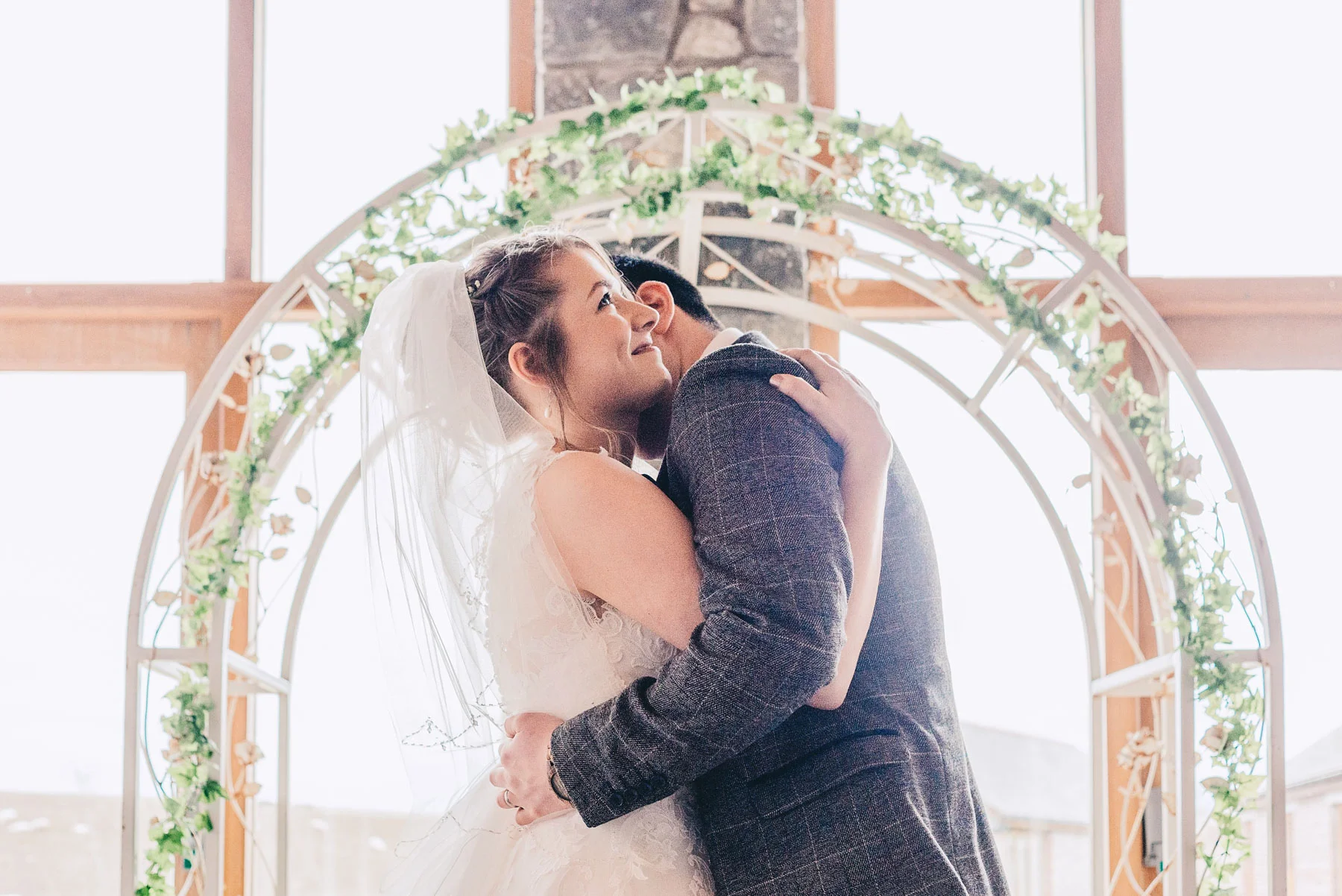 Bride and Groom hug during wedding service at Rosedew Farm, Llantwit Major, South Wales