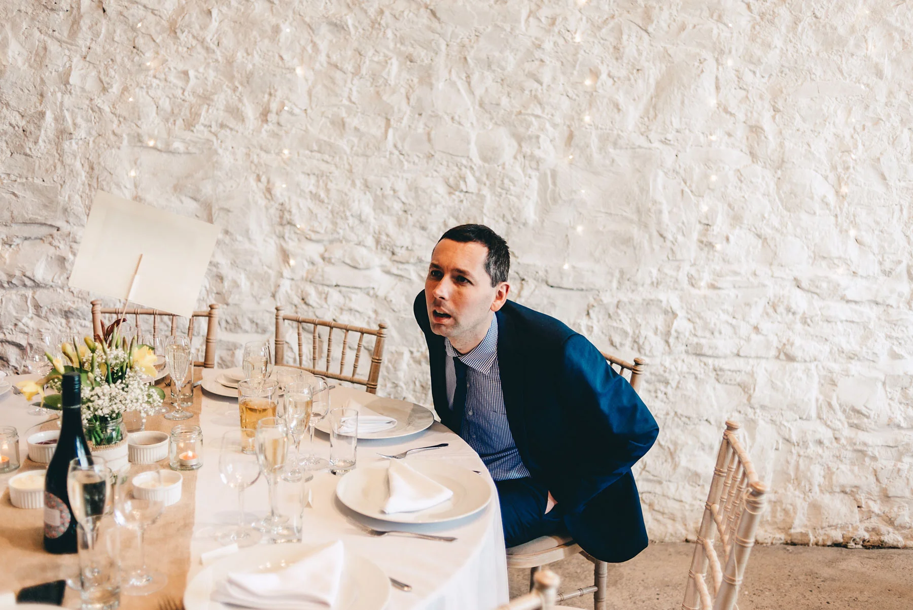 Man stares at table decorations at wedding