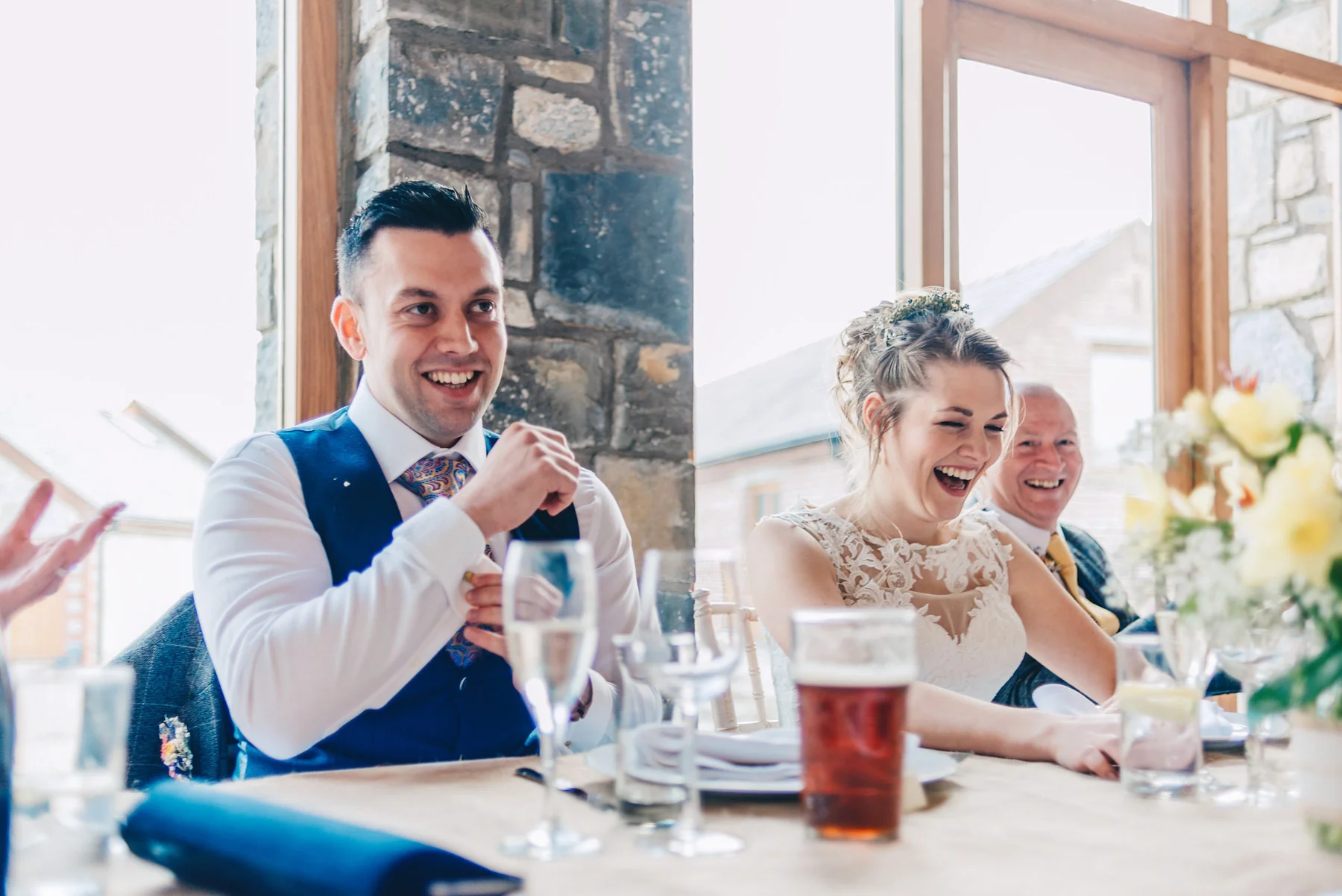 Bride and groom laugh at speeches