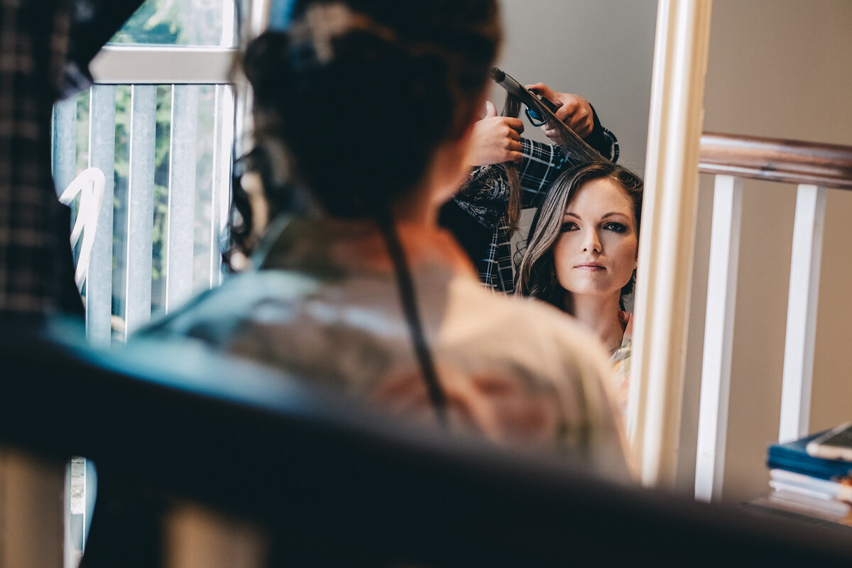 Bride has her hair styled in the morning of her wedding