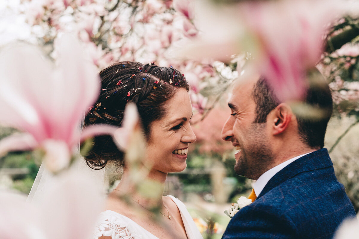 Bride and groom in Didsbury Parsonage Gardens with flowers in full bloom