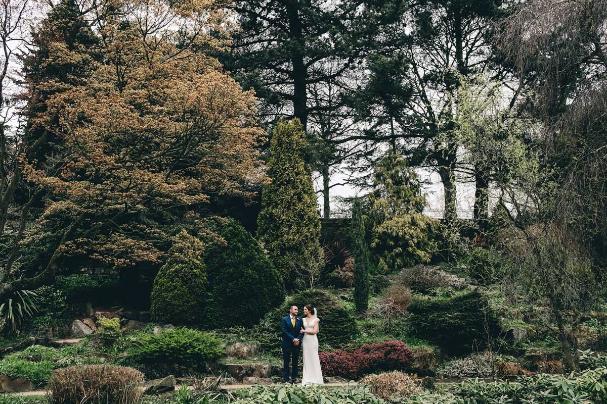 Dramatic shot of bride and groom in Fletcher Moss Park Didsbury