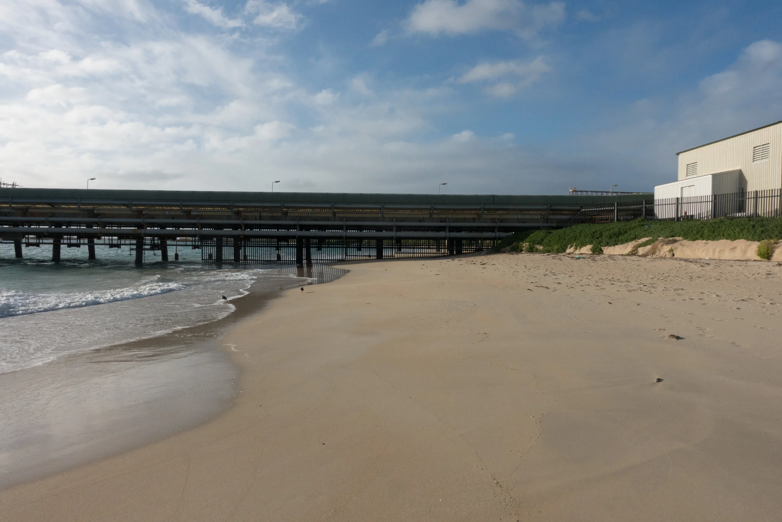 Plate 28: Close up of the jetty at the northern end of Kwinana Beach showing the gates underneath the jetty blocking further access and the property fence prevent access around it.