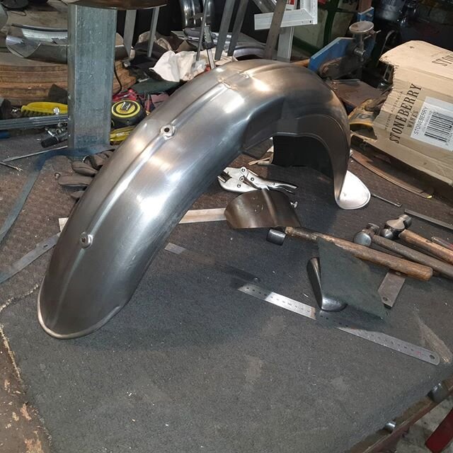 1939 Excelsior Manxman front guard . First one of these weve made . Half valance with the rear skirt folded around to the rear . Seam joint in the middle . Number plate pressings along with a pressing fot the centre mount and the front stand . 
Fork 